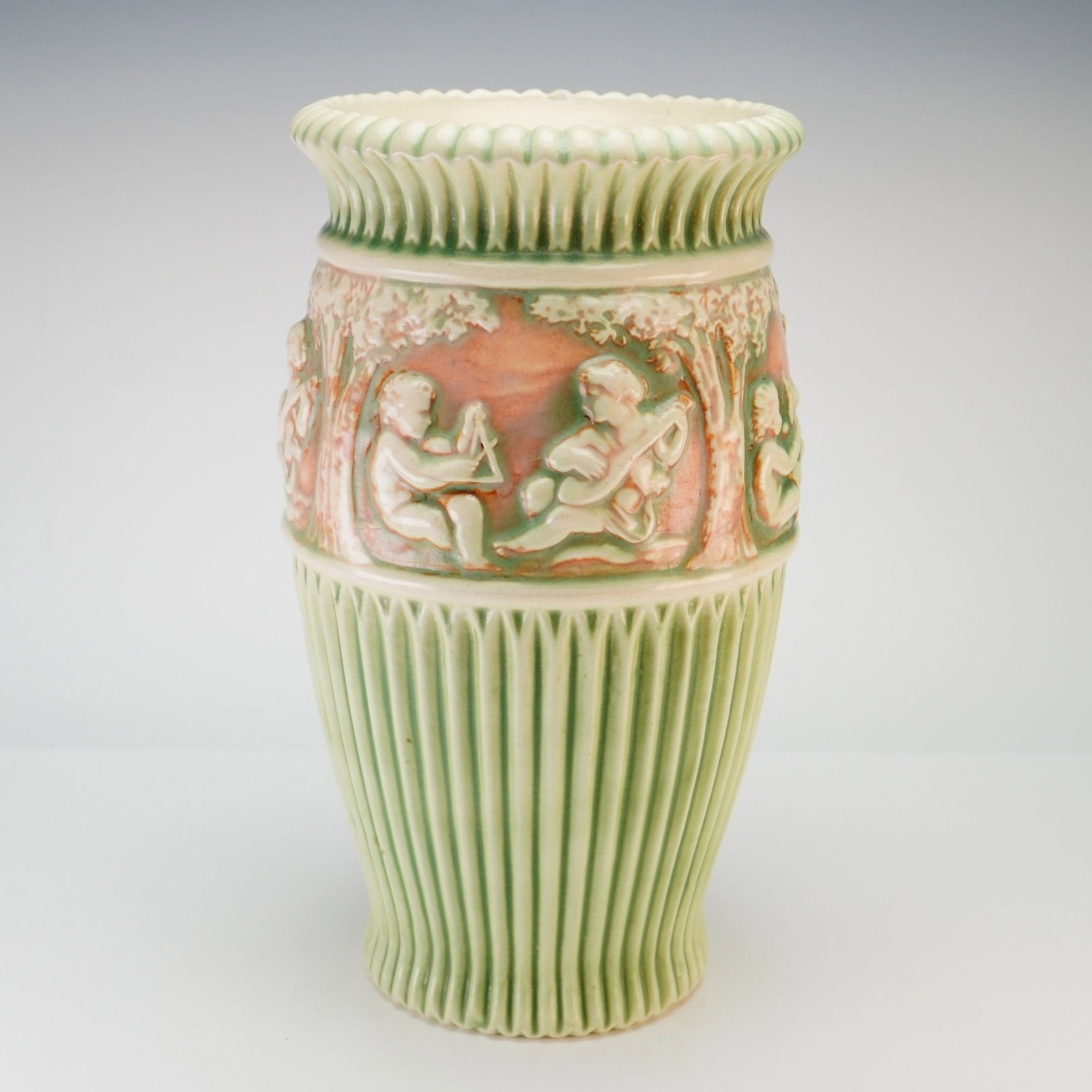 Roseville Pottery Cherub Vase, Donatello Pattern c. 1915: This art pottery vase was produced by the Roseville Pottery Company of Zanesville, Ohio, as part of the Donatello pattern introduced circa 1915. The vessel is constructed of glazed earthenware and fea