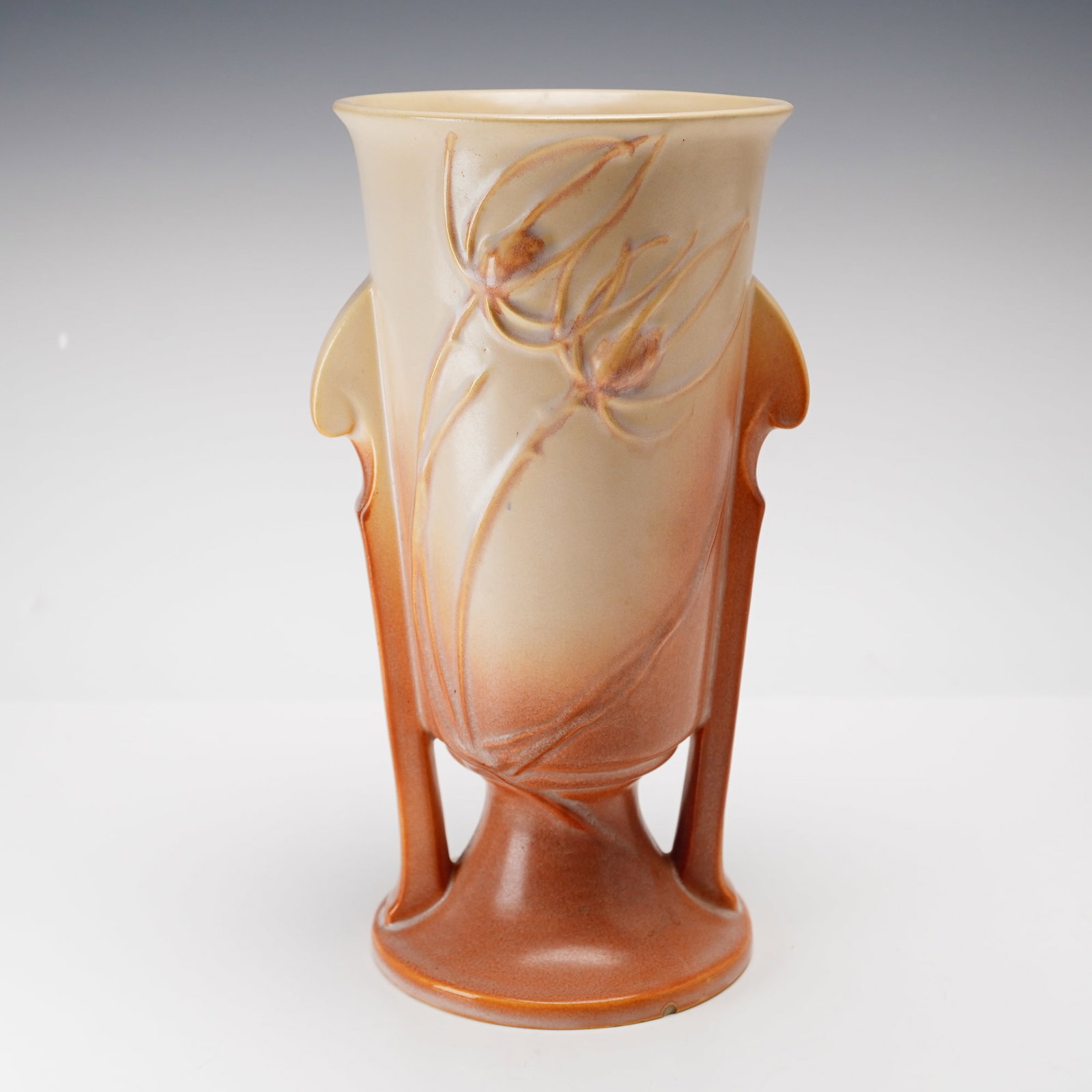 Roseville Zephyr Lily Art Pottery Pedestal Vase: Roseville Pottery art pottery pedestal vase in the Zephyr Lily pattern, which was originally introduced in 1946. The vessel features a slightly flared rim and a tapered body with integrated, stylized 
