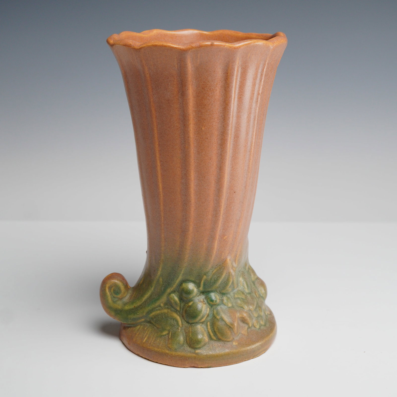 McCoy Pottery Cornucopia Vase: This ceramic vase is attributed to McCoy Pottery and features the Cornucopia pattern. The earthenware vessel is designed in a flared trumpet form with a vertically fluted body and a scalloped rim.