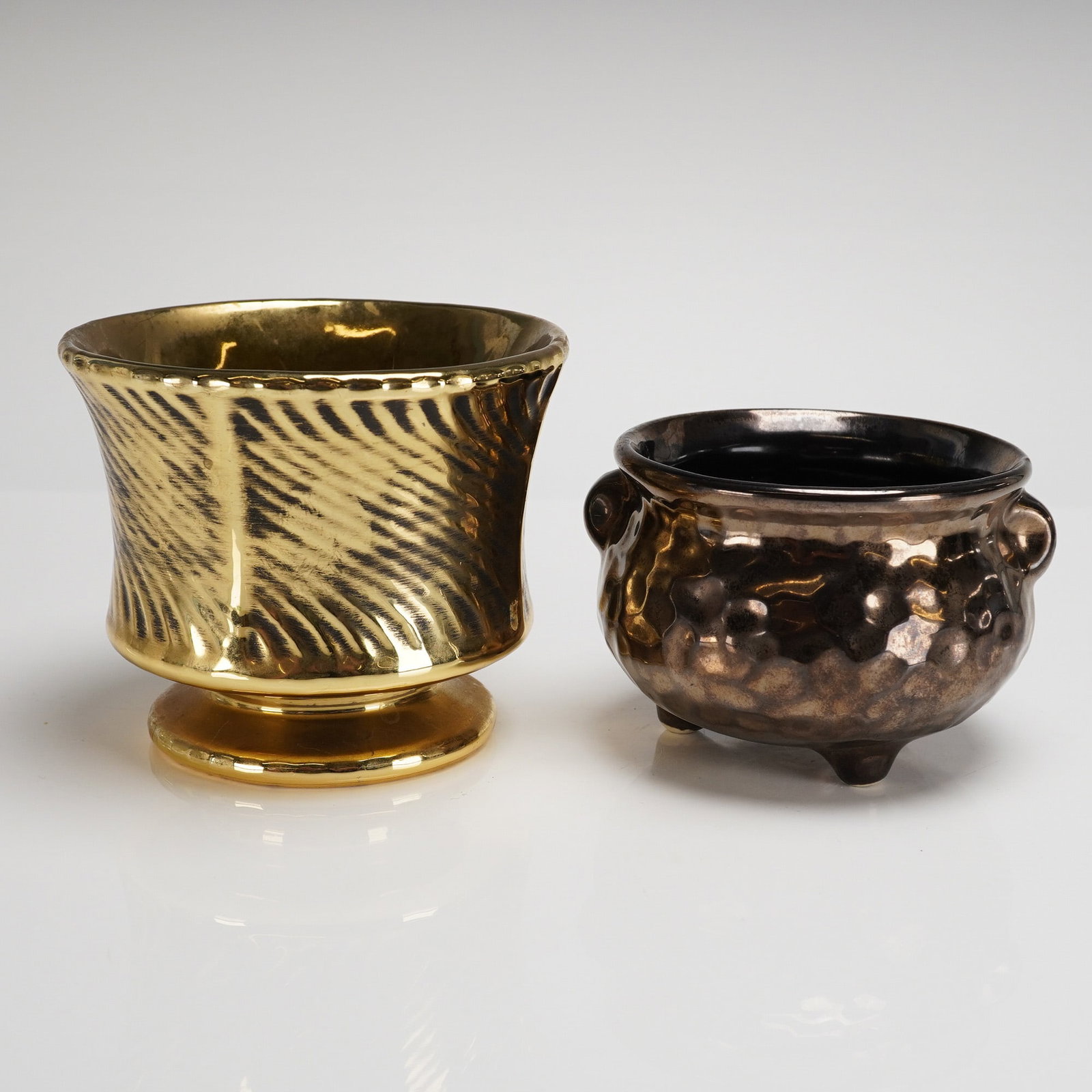 Two McCoy Pottery Floraline Luster Planters: Two ceramic decorative planters attributed to McCoy Pottery, likely from the Floraline line, exhibiting metallic luster glazes and a mid-century aesthetic. The collection consists of two distinct item