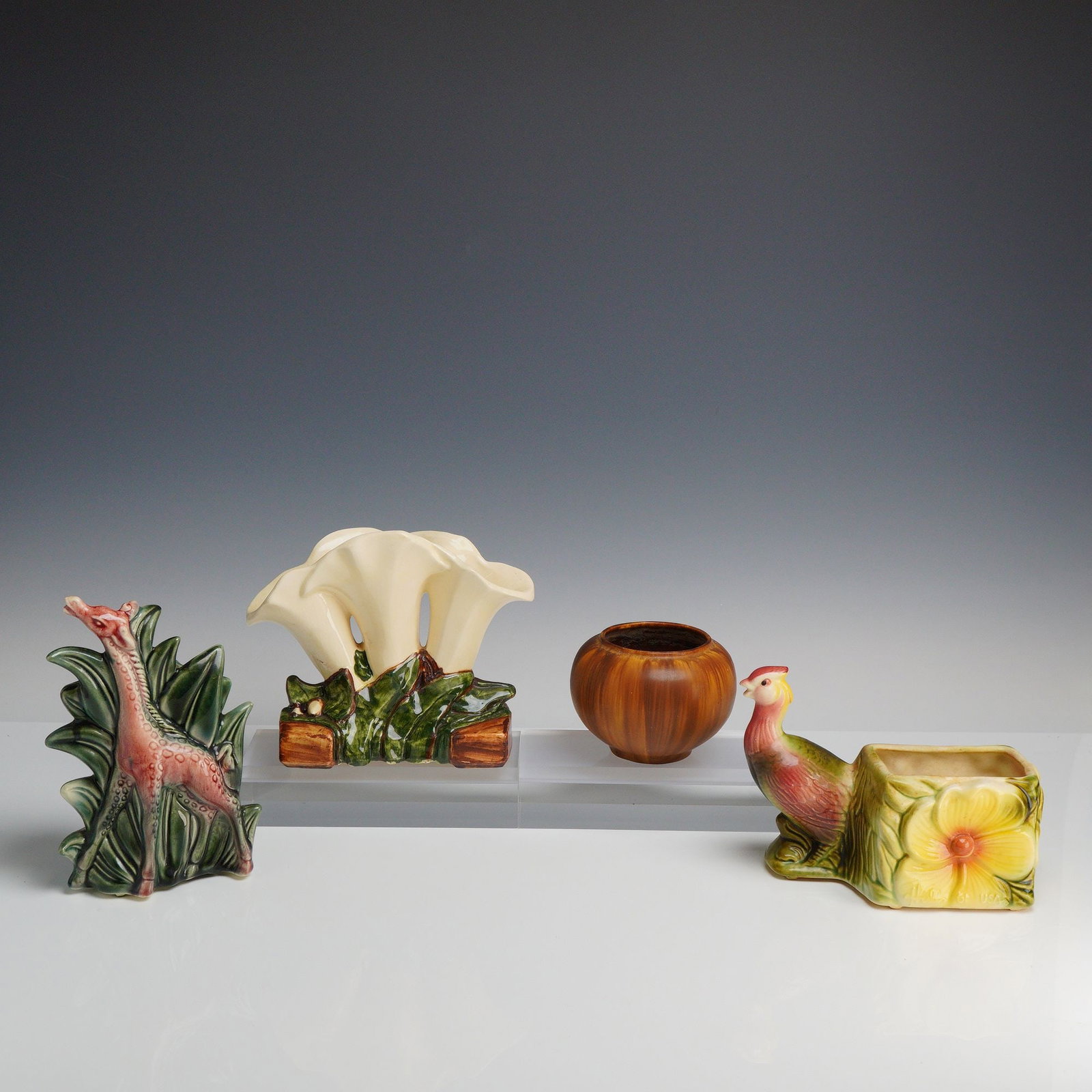 McCoy and Hull Pottery Animal and Floral Figure Vases and Planters: This collection of four vintage American art pottery pieces features various animal and floral motifs. The set includes a McCoy Giraffe figural planter, model 731, depicting a giraffe standing amidst 