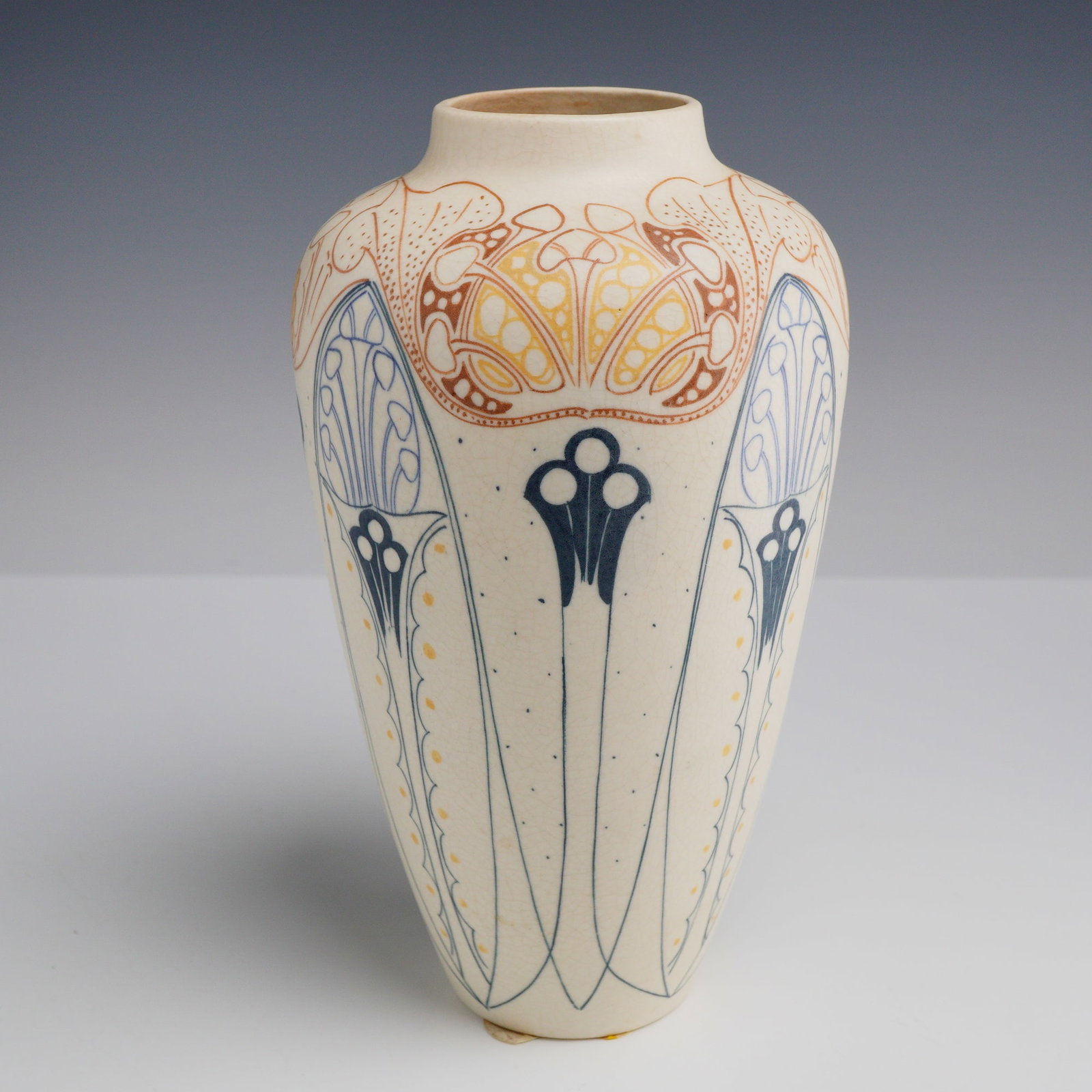 Arnhem Matte Glaze Pottery Vase, c. 1910: An Art Nouveau ceramic vase features an elongated ovoid body tapering toward the base with a short, slightly recessed neck. The exterior is decorated with stylized botanical motifs, including tall sle