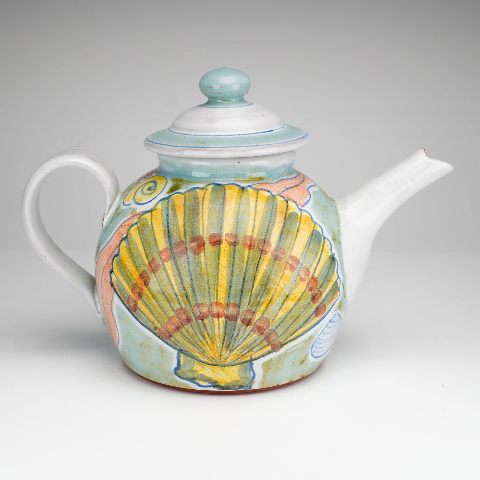 Daphne Carnegy Hand-Painted Tin-Glazed Earthenware Teapot: Hand-painted ceramic teapot with lid, made by Daphne Carnegy. This piece is crafted from tin-glazed earthenware over a red clay body in the majolica tradition. The teapot has a globular body, a straig