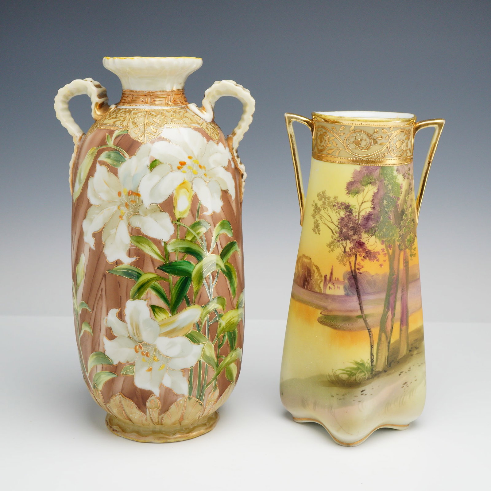 Two Nippon Hand-Painted Porcelain Vases Including Scenic and Floral Motifs, 1890s: This lot consists of two hand-painted porcelain vases from the Nippon period, produced by the Morimura Brothers. The first vase is an ovoid baluster form with two scroll-style handles at the neck and 