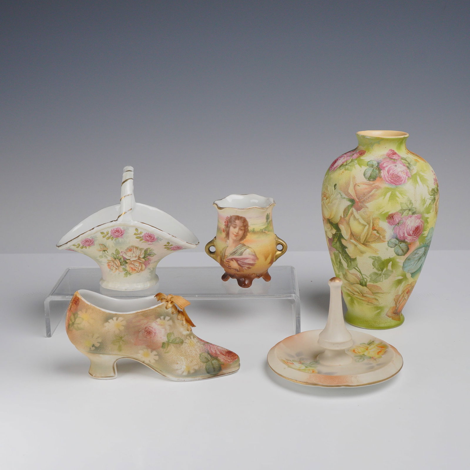 5pc Royal Bayreuth Floral Porcelain Vase, Pot, Basket, Ring Holder, and Shoe Figurine: This quintet of Royal Bayreuth ceramic decorative arts highlights the intricate floral designs and varied forms produced in Bavaria. The group is anchored by four pieces"a tapered globular vase, an or