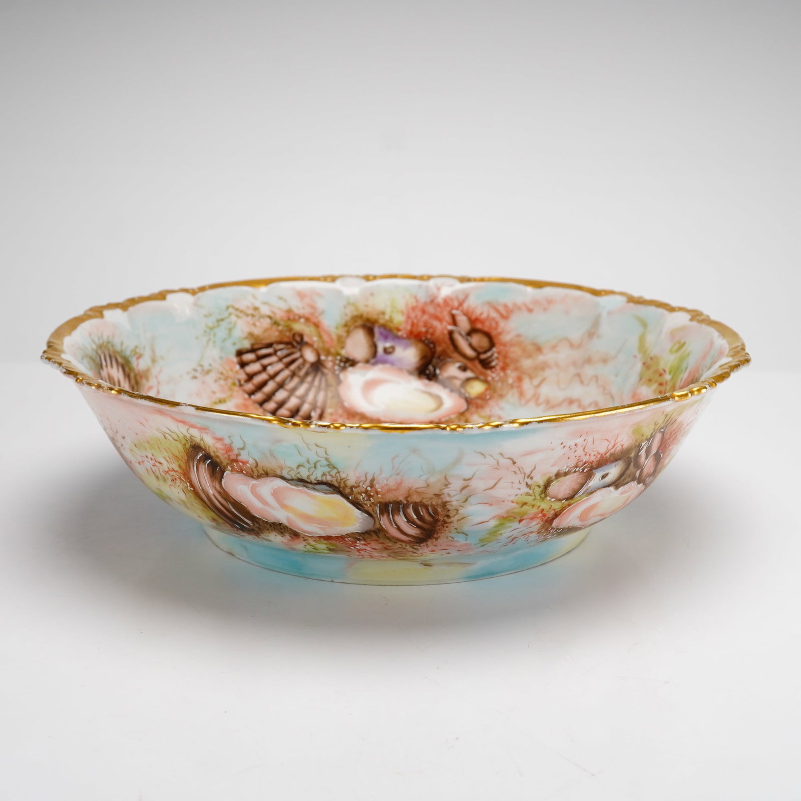 Rosenthal R.C. Bavaria Claire Hand-Painted Porcelain Sea Life Bowl: A shallow porcelain bowl featuring a scalloped rim with gilded edging. The piece is decorated on both the interior and exterior with a continuous hand-painted undersea motif. The decoration includes v