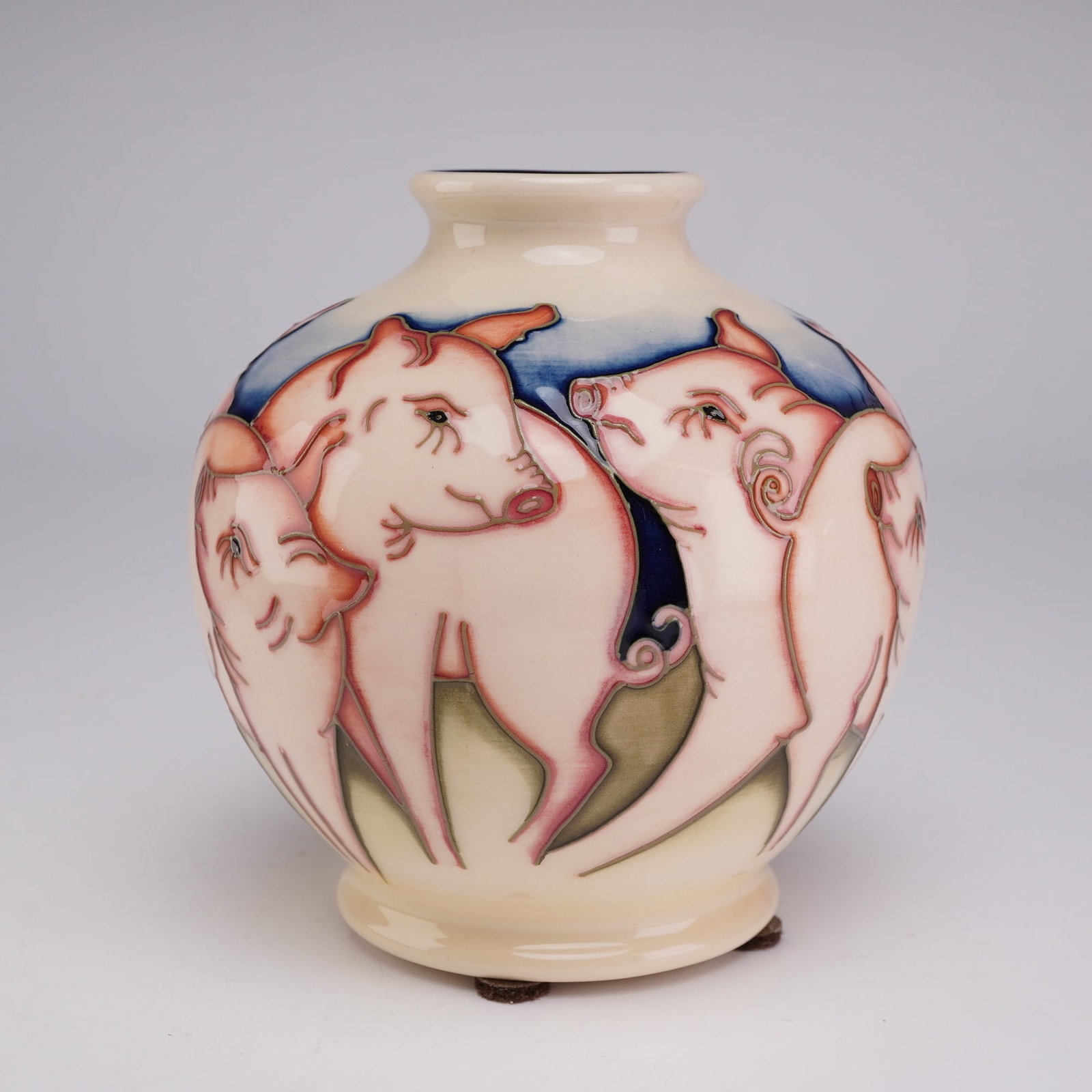 Moorcroft Pottery by Kerry Goodwin Ceramic Vase, Fowlers Farmyard Pigs: The small bulbous earthenware vessel is constructed with a short neck, a slightly flared rim, and a circular footed base. The exterior is decorated with a continuous wrap-around scene of pink pigs wit