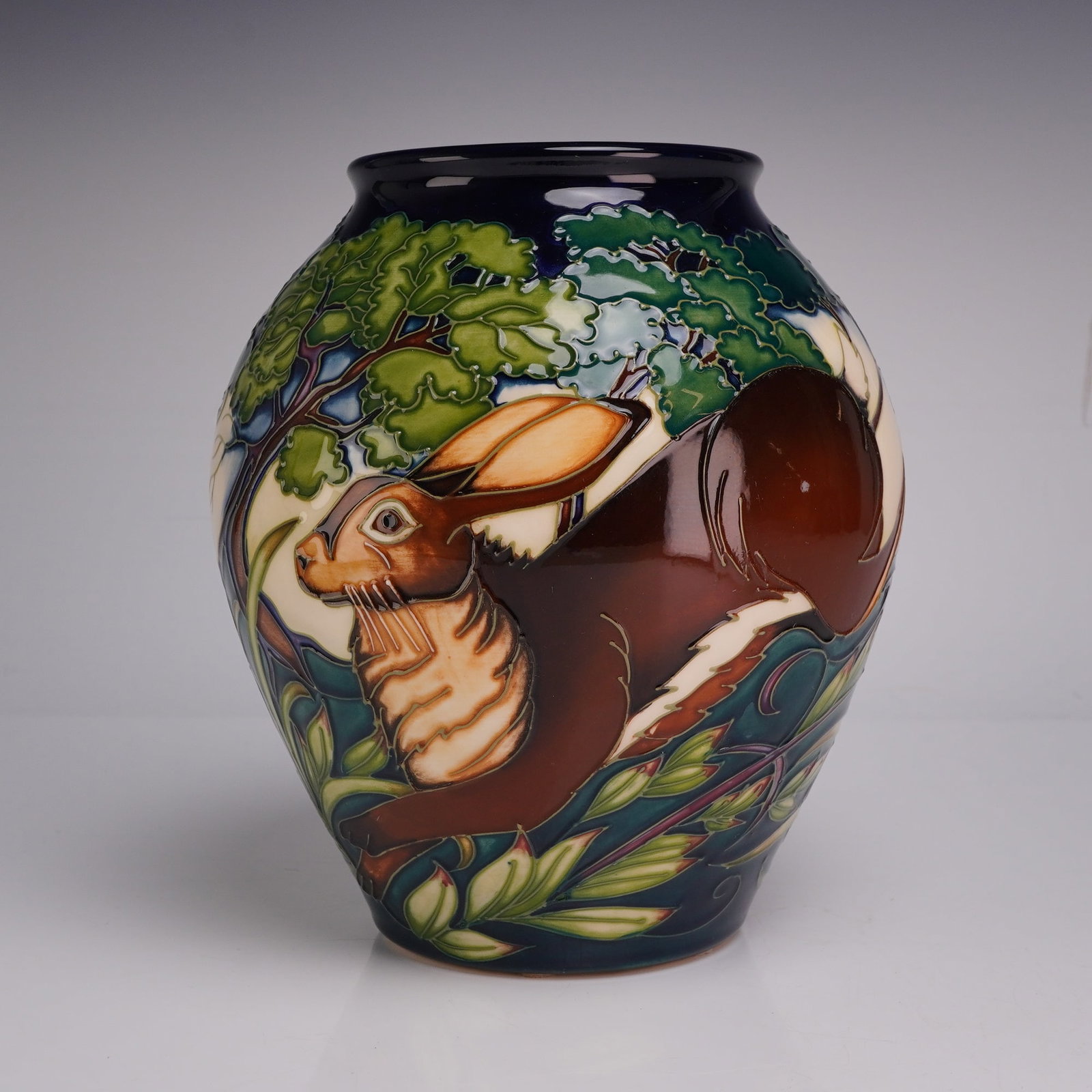 Moorcroft Flanders Moss Limited Edition Pottery Vase Signed and Dated 2002: This Moorcroft earthenware vase features the Flanders Moss pattern designed by Philip Gibson. The ovoid, bulbous form is decorated using the tubelining technique, depicting hares in a stylized landsca