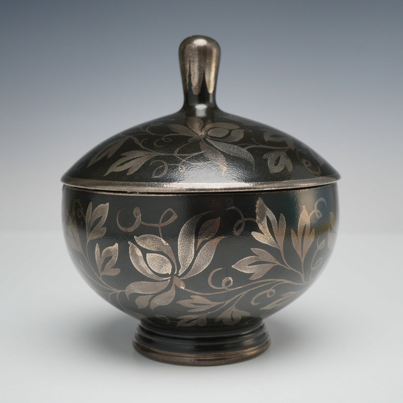 Wedgwood Black Basalt Lidded Footed Bowl: This Wedgwood lidded footed bowl is constructed from black basalt ceramic. The vessel features a matte black exterior and a high-gloss dark green glazed interior. The exterior of both the bowl and the
