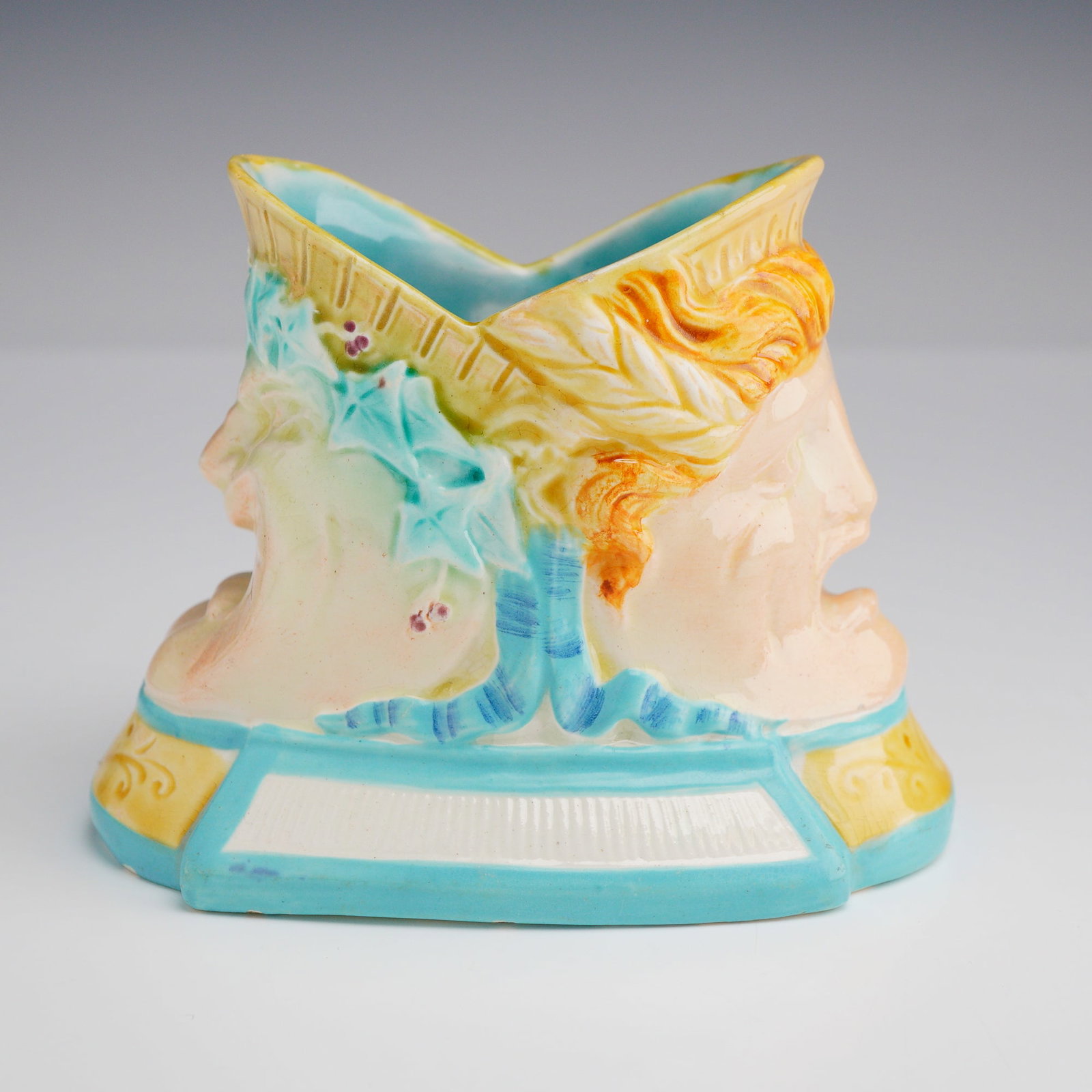 Wedgwood Majolica Theatrical Mask Spill Holder: A Victorian era majolica spill holder or small decorative vessel. The item is of lozenge shaped form, modeled in high relief with two back to back theatrical masks. One side depicts a male tragic mask