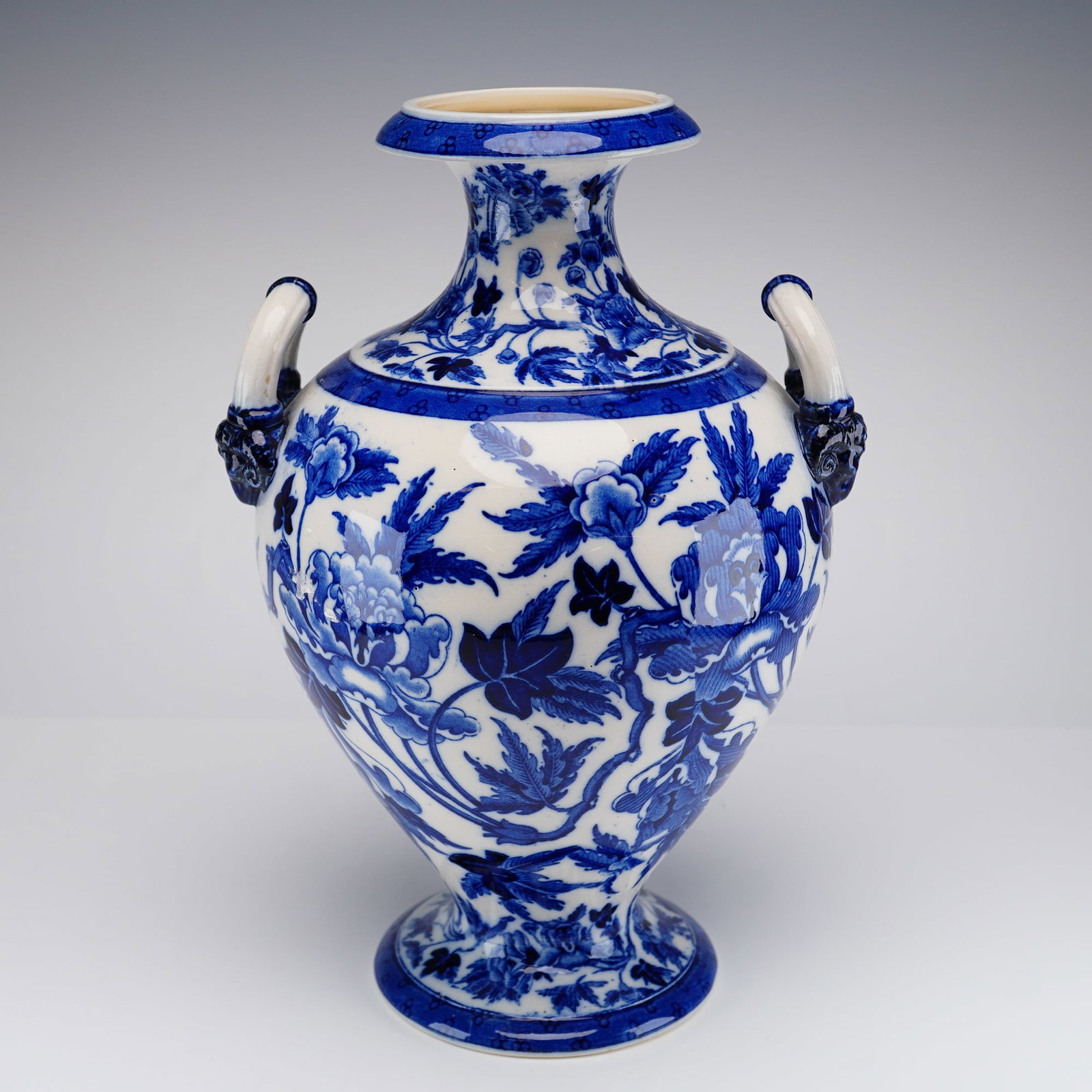 Wedgwood Blue and White Peony Pattern Twin-Handled Vase: This Wedgwood earthenware twin-handled vase features an amphora-like form with a wide, flaring rim and a waisted neck. The bulbous ovoid body tapers to a circular pedestal foot and is flanked by two u