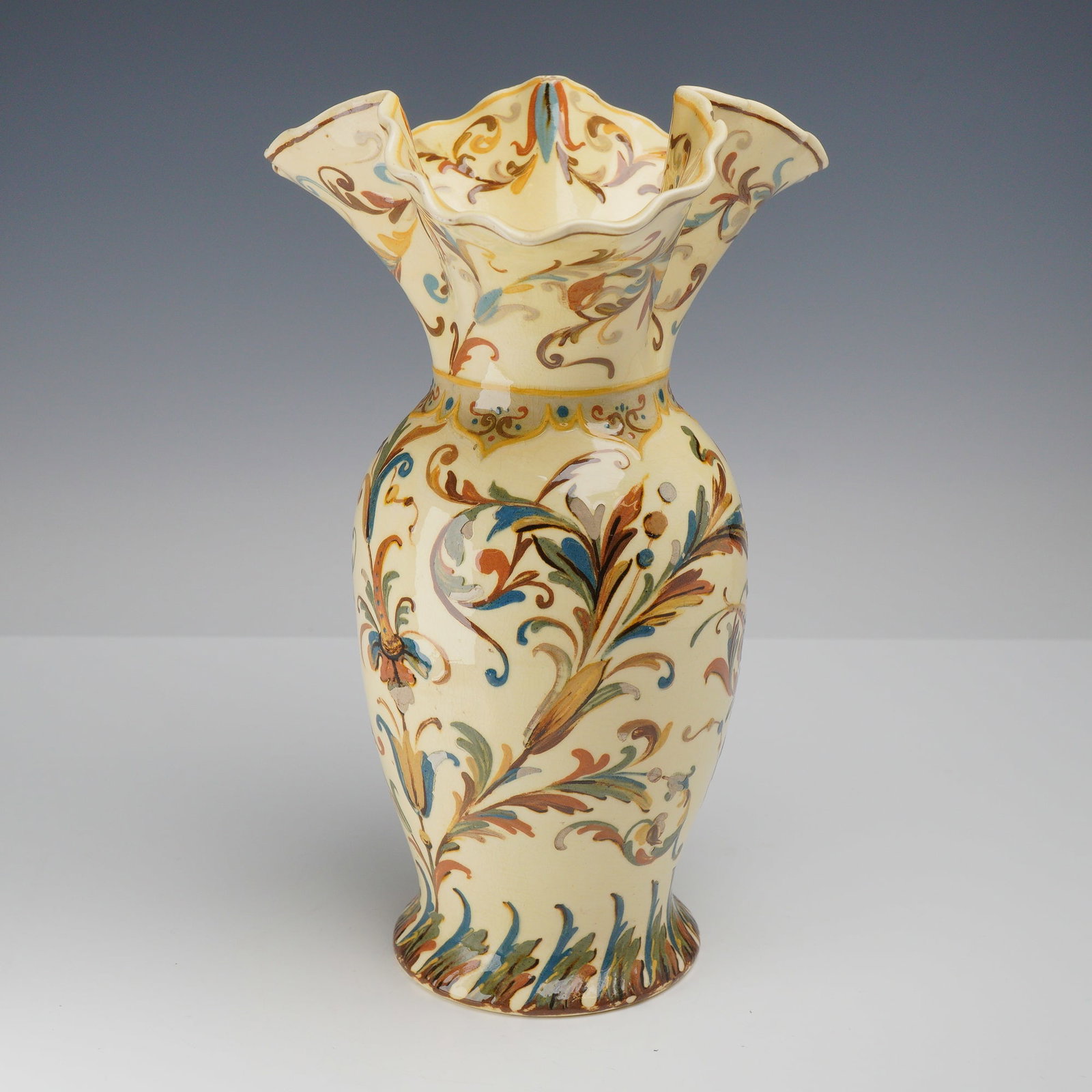 Wedgwood Hand Painted Earthenware Vase with Ruffled Rim circa 1880: This Wedgwood earthenware vase features an ovoid body with a cinched neck and a deeply ruffled scalloped rim. The piece is finished in a cream-colored glaze and decorated with hand-painted flowing fol