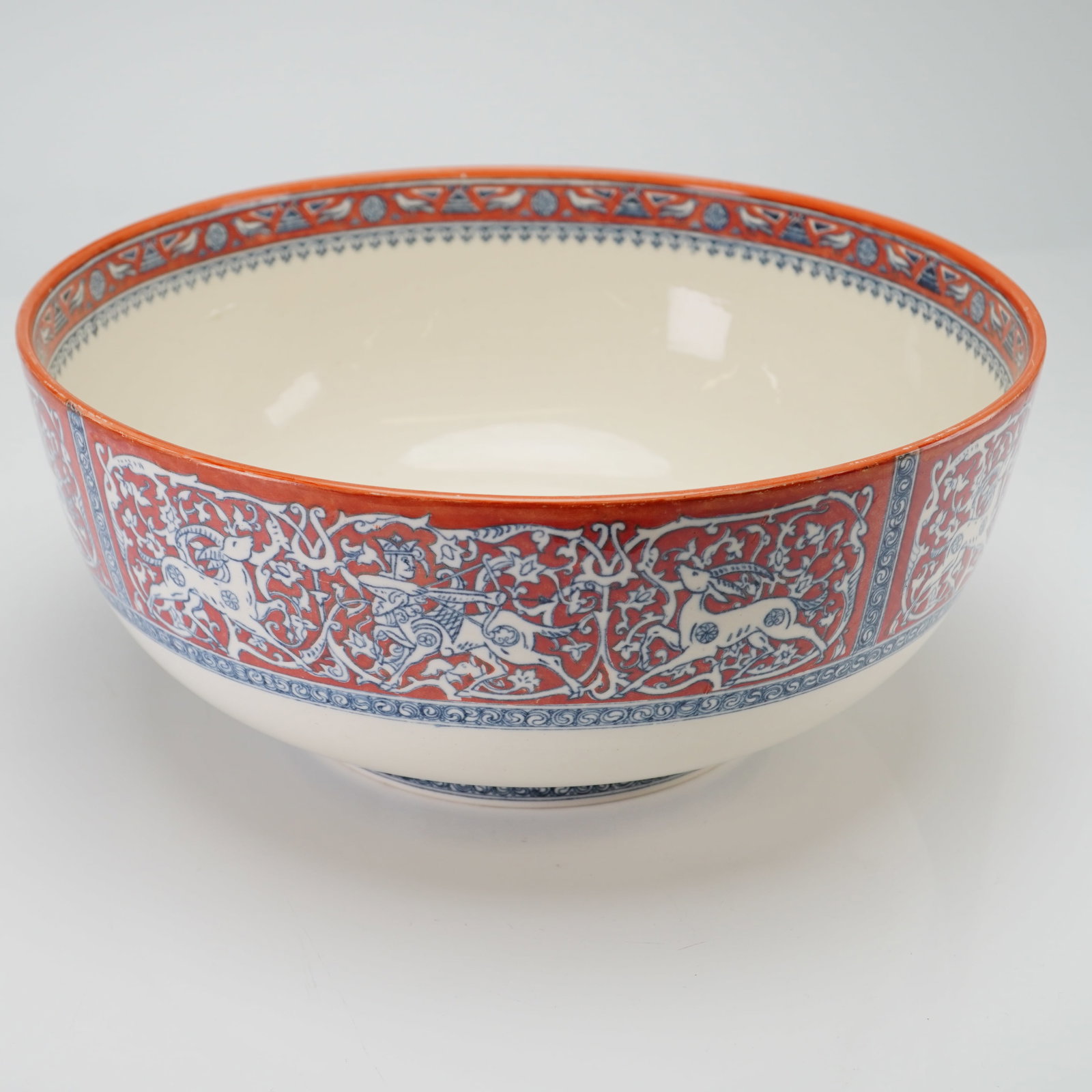 Wedgwood Florentine Rice Bowl: A large circular centerpiece bowl manufactured by Wedgwood. The bowl is composed of fine earthenware with a cream-colored ground, featuring intricate transfer-printed decorations in iron-red and under