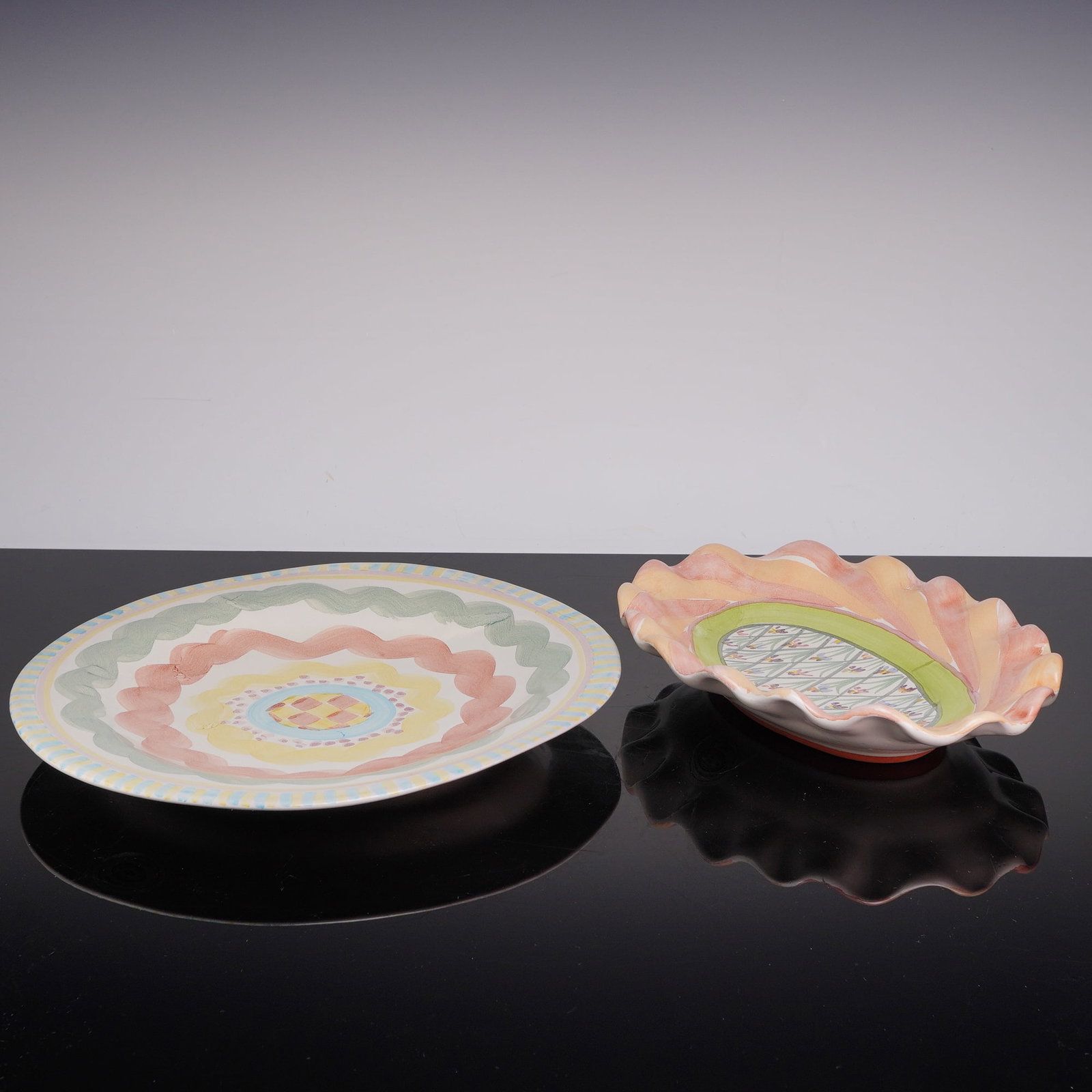 2pc MacKenzie-Childs Aurora Plate and Bearded Iris Bowl: This pair of artisan MacKenzie-Childs stoneware includes an Aurora Plate and a Bearded Iris Bowl. Both items feature a white glazed surface with hand-painted polychrome decoration and unglazed terraco