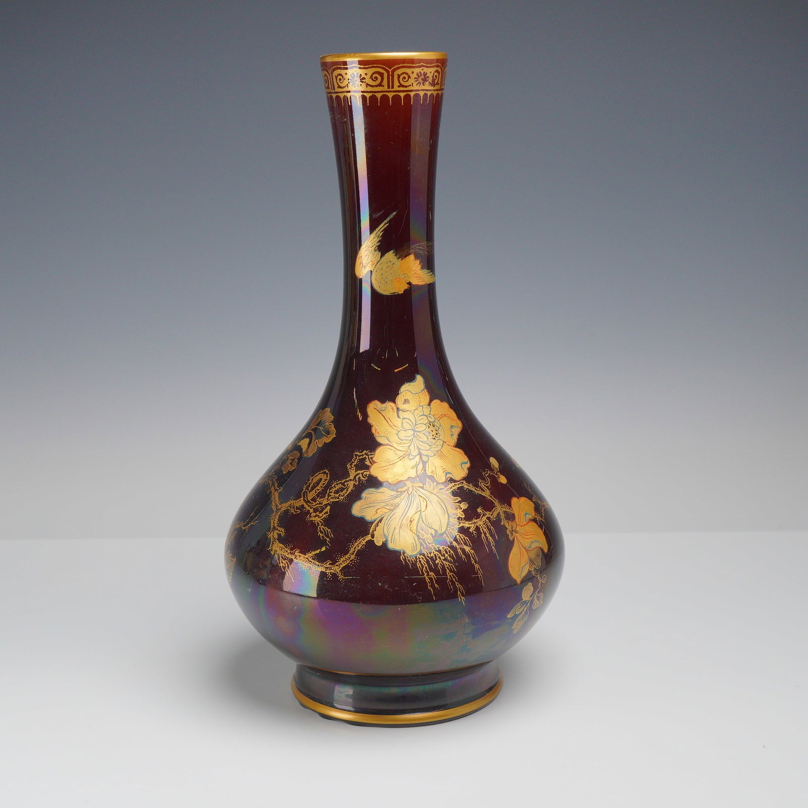Loetz Style Art Nouveau Gilded Iridescent Vase: Art Nouveau iridescent vase in the style of Loetz, featuring a tall, slender tapering neck over a bulbous, compressed-globular base. The piece is crafted from deep claret-colored glass with a lustrous