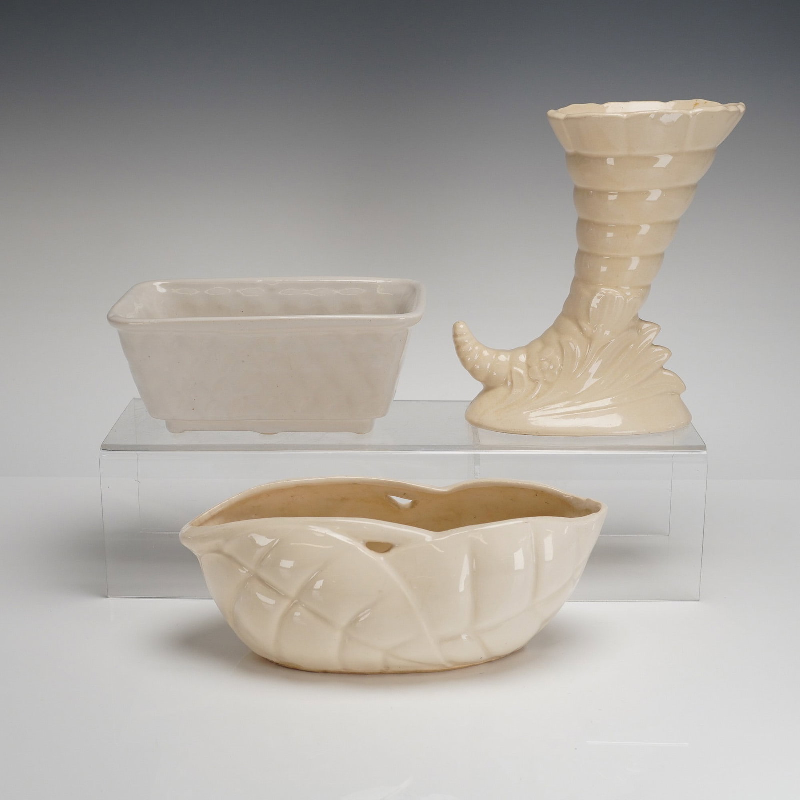 3 McCoy Pottery Planters - Cornucopia, Rectangle & Oval: A trio of glazed ceramic planters attributed to McCoy Pottery, characteristic of mid-century American art pottery. The collection includes three distinct forms, all finished in a uniform pale ivory or