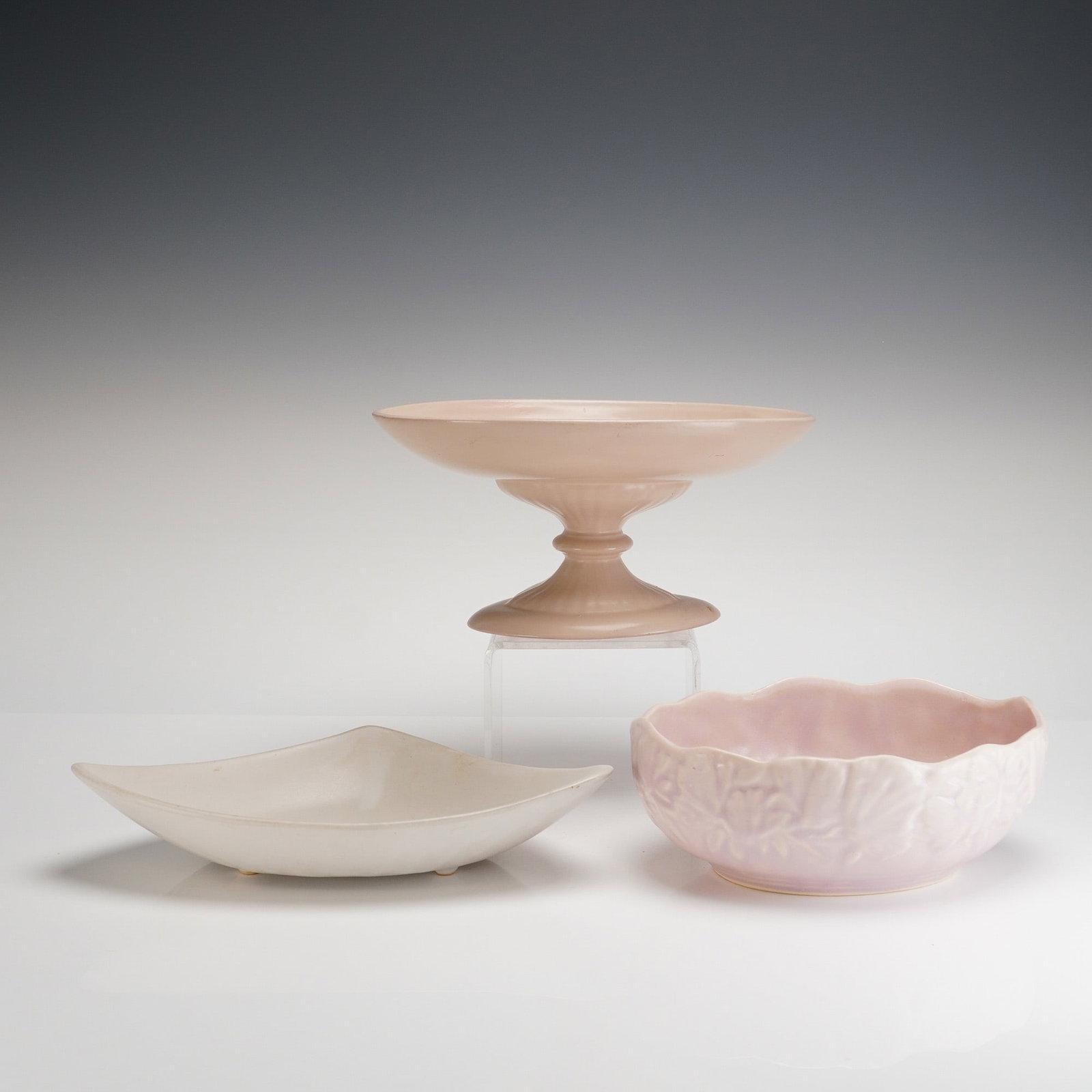 Three American Mid-Century Pottery including Hyalyn and Floraline: A collection of three pieces of glazed earthenware decorative pottery, dating to the American Mid-Century period. The collection includes a pedestal compote, a shallow footed bowl, and a round decorat