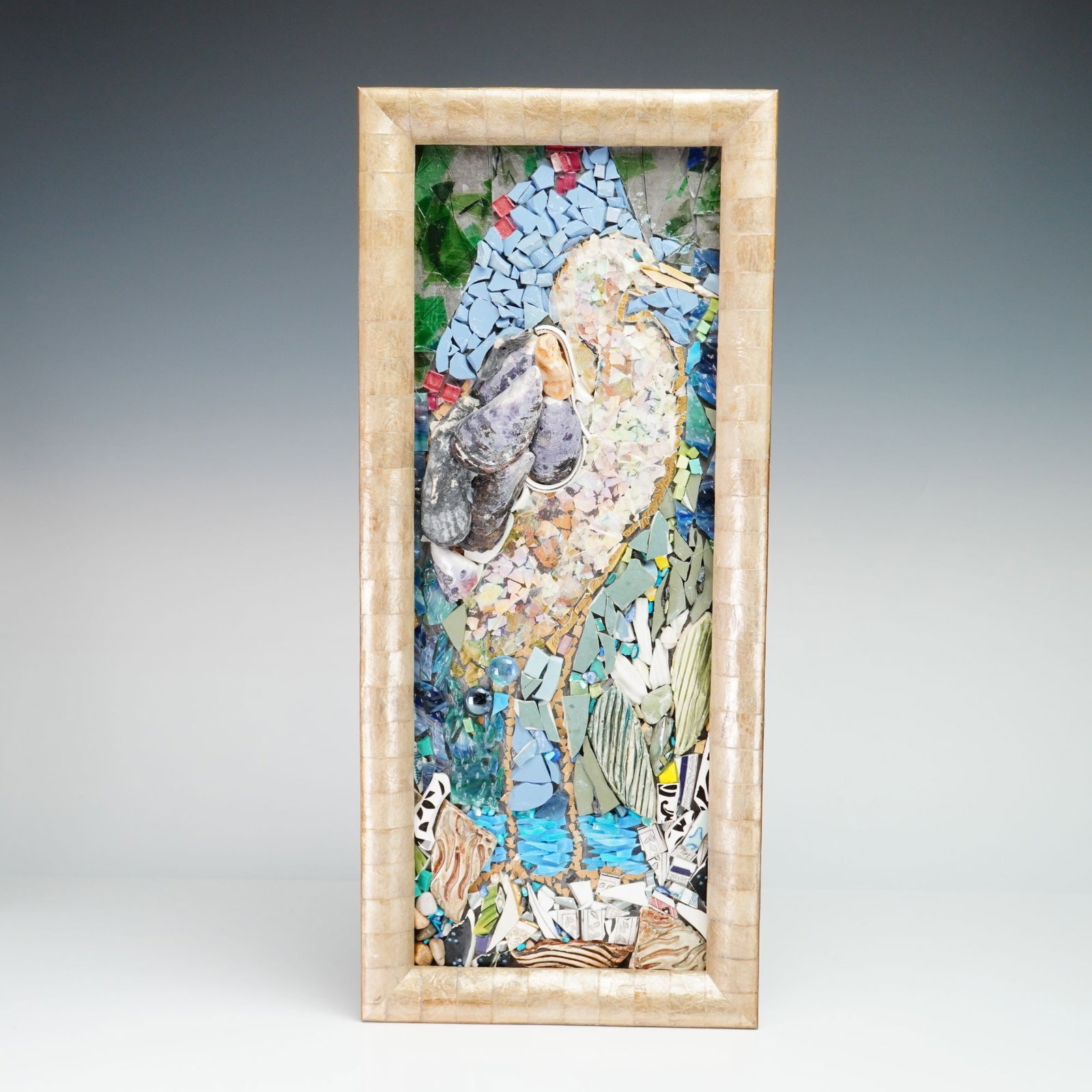 Suzanne Rubin Pique-Assiette Mixed Media Mosaic Bird Art: This vertical mixed media mosaic is the work of artist Suzanne Rubin, dated 2014. The piece employs pique-assiette and assemblage techniques to create a textured, multi-dimensional depiction of a wadi