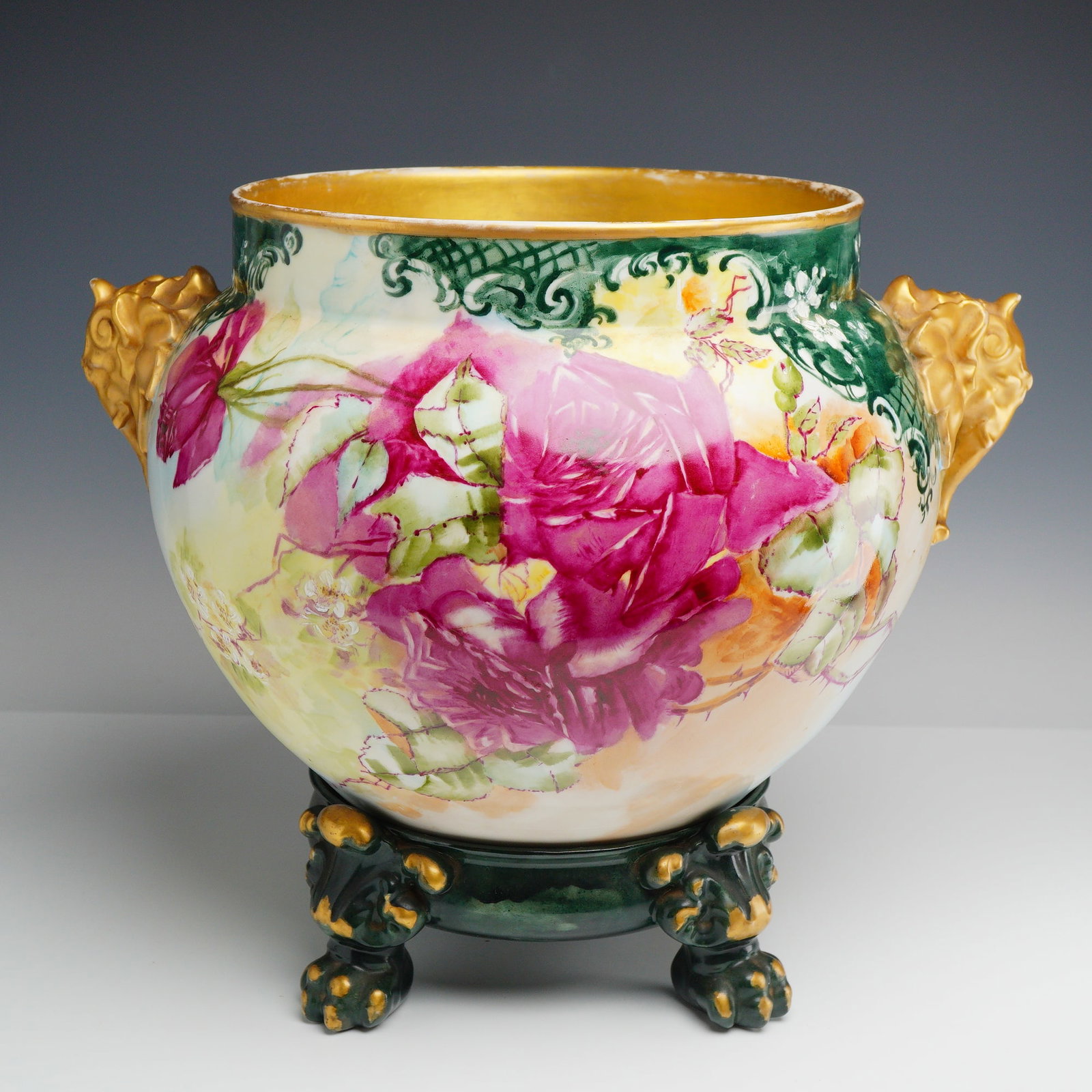 Jean Pouyat Limoges Hand-Painted Porcelain Jardiniere with Elephant Handles and Stand: A Jean Pouyat Limoges porcelain jardiniere and separate coordinating stand. The vessel features a bulbous body with two molded handles in the form of elephant heads with downturned trunks, finished in
