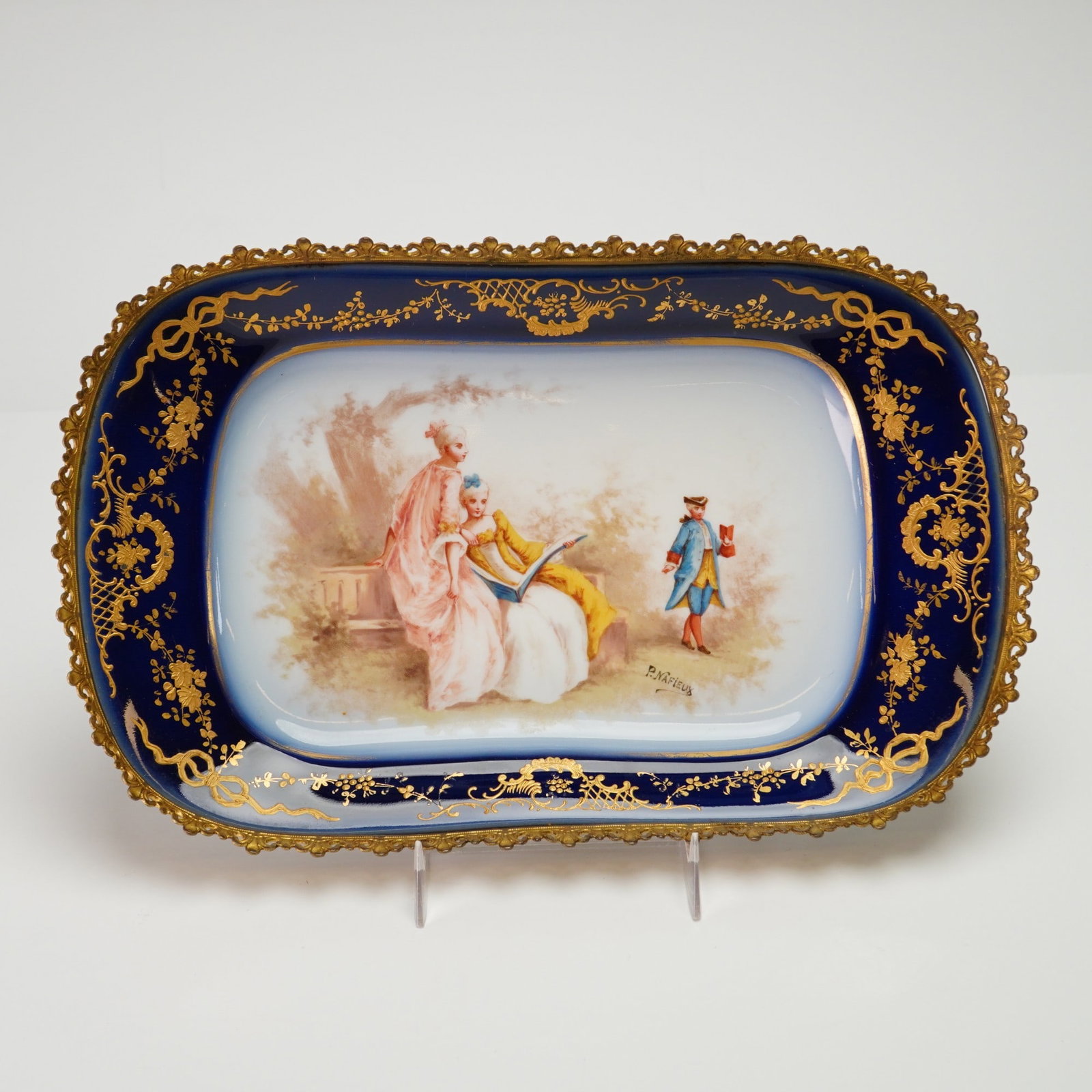 Sevres-Style Gilt Metal Mounted Porcelain Centerpiece Tray Signed P. Nafieux: A 19th-century Sevres-style porcelain centerpiece tray of rectangular form with rounded corners. The center features a hand-painted scene in the Rococo taste depicting a galante with two women in 18th