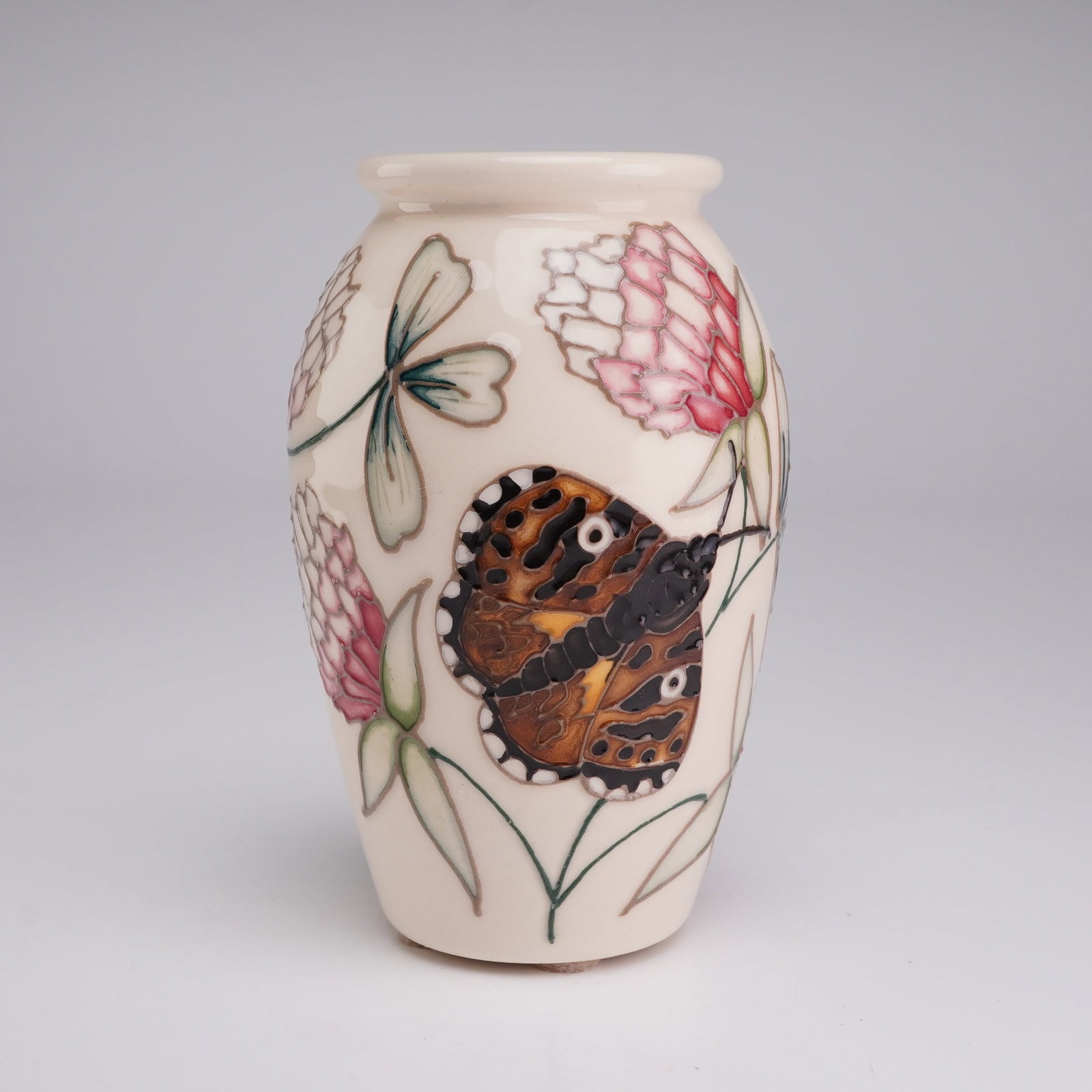 Moorcroft Pottery by A. Amison Limited Edition Bud Vase, Mother Shipton Moth: The vessel features an ovoid form with a slightly flared rim. The decoration is executed using the traditional Moorcroft tubelining technique, creating raised outlines for the hand-applied colored gla