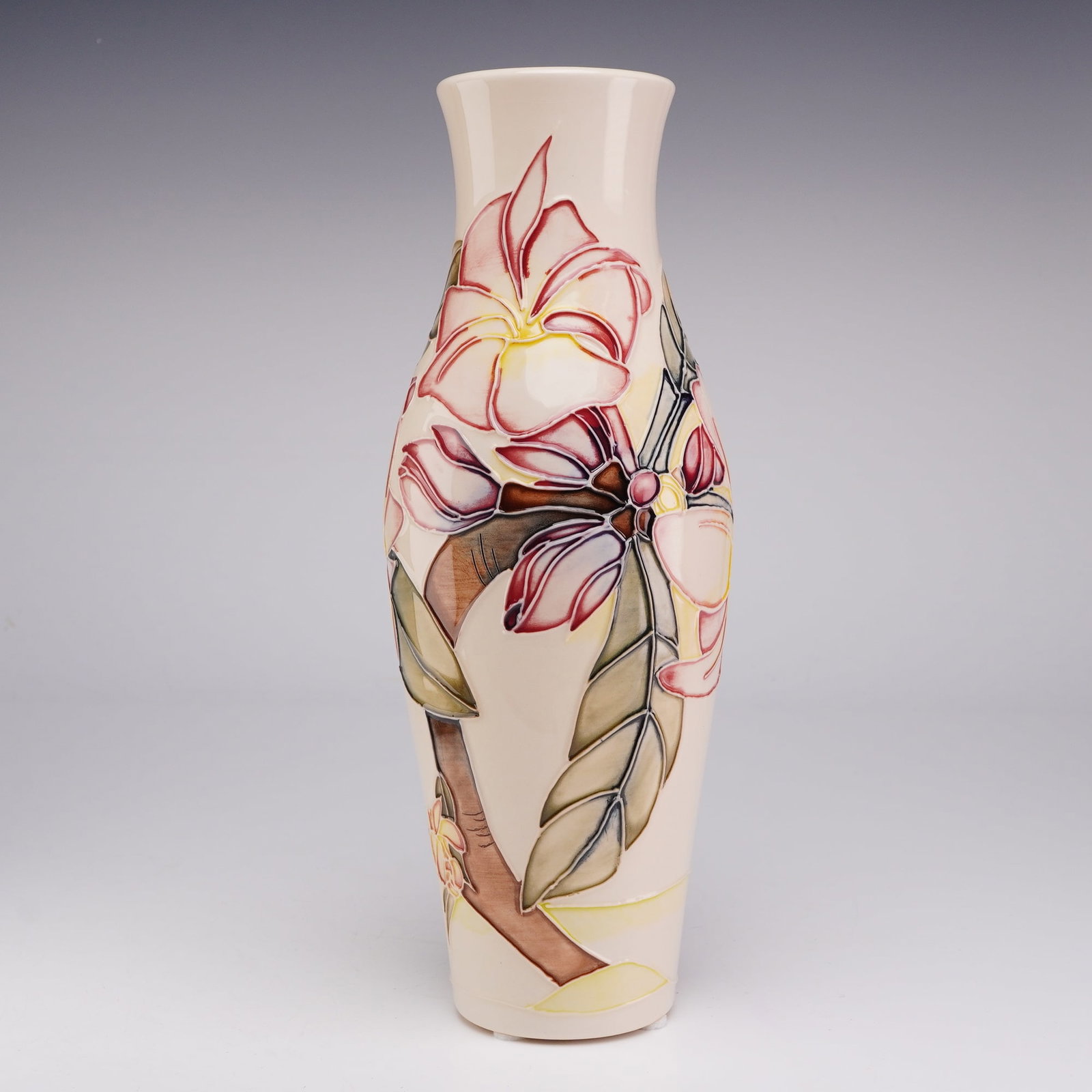 Moorcroft Pottery by Emma Bossons Vase, Frangipani Pattern: A Moorcroft vase of slender, waisted form. The exterior features the Frangipani pattern, executed in tubelined and hand-painted decoration. The design depicts plumeria blossoms in shades of pink, yell