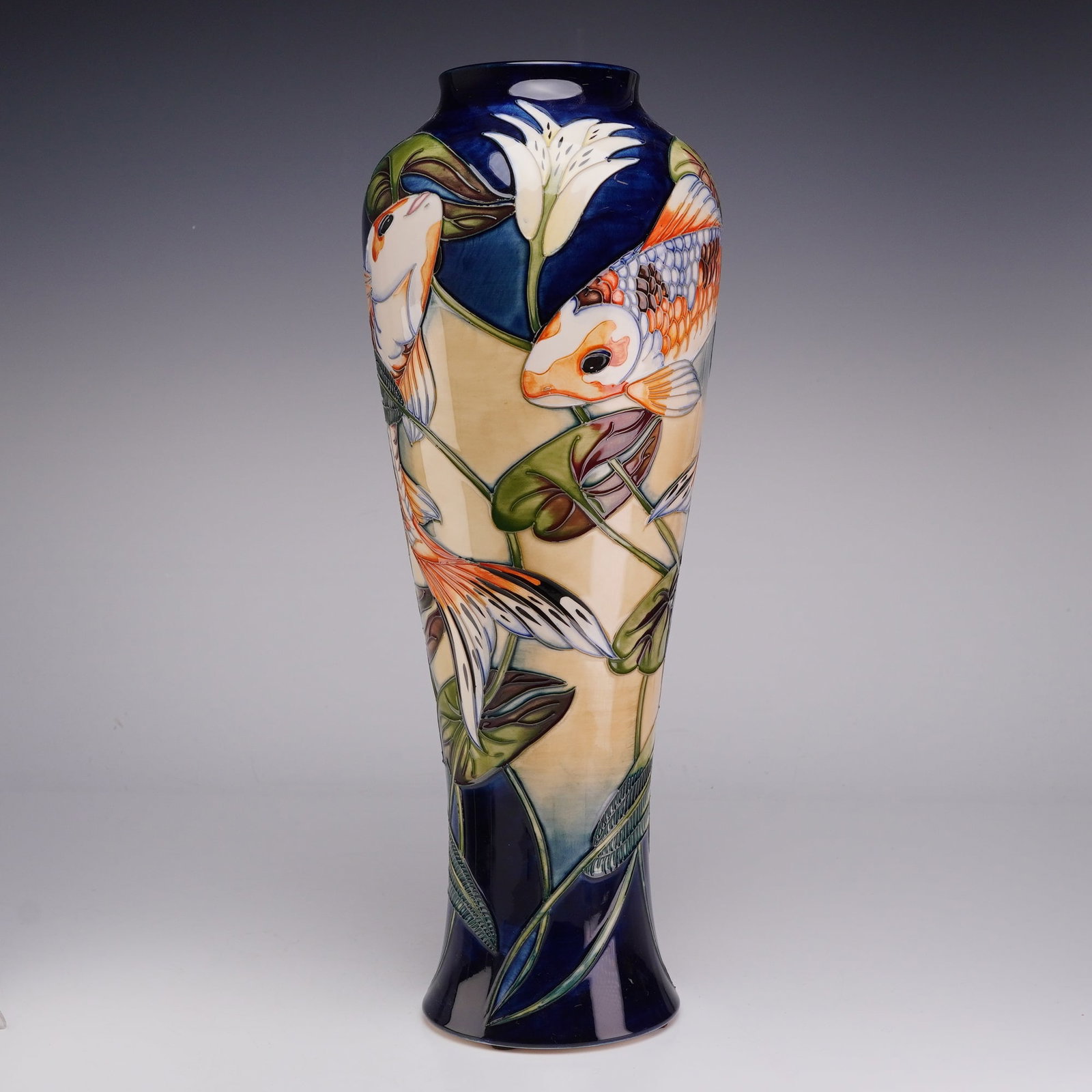 Moorcroft Pottery by Philip Gibson Vase, Quiet Waters: This tall, waisted vessel is decorated using the signature tube-lining technique, where raised slip outlines are hand-filled with underglaze colors before being finished with a clear lead glaze. The d