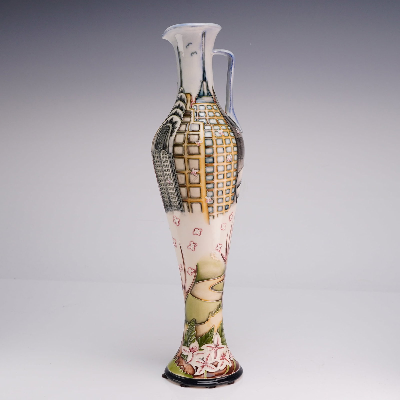 Moorcroft Pottery Vicky Lovatt New York Macy's Ewer MCC 2008: A Moorcroft Pottery ceramic ewer featuring the New York pattern designed by Vicky Lovatt. This slender, high-handled vessel is decorated using the signature tube-lining technique and hand-painted glaz