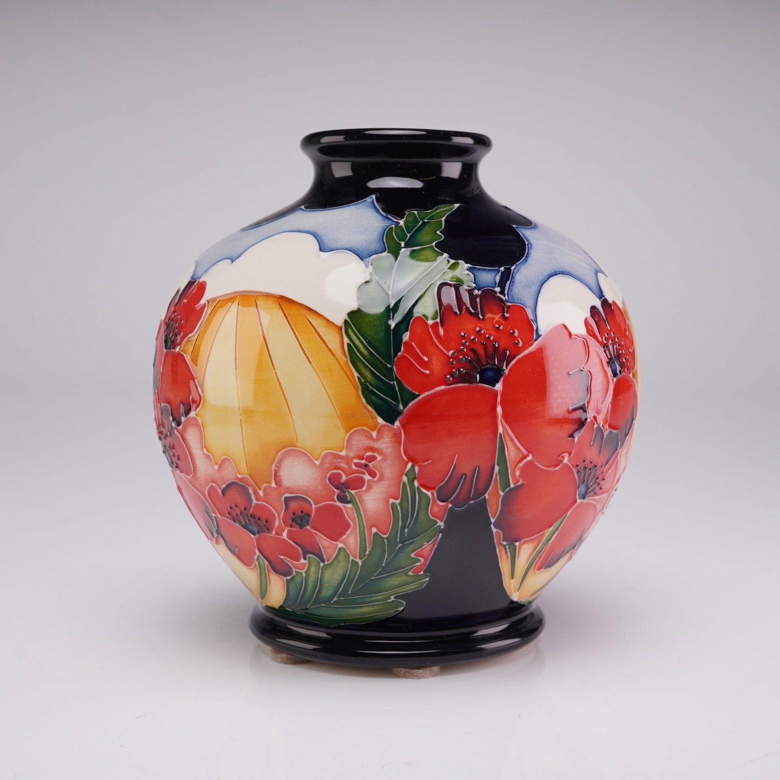 Moorcroft Pottery Squat Ceramic Trial Vase, 2016: This small, bulbous ceramic vase features a globular body with a short, flared neck and a stepped, circular base. The exterior is decorated with a vibrant landscape and floral motif executed in a tube