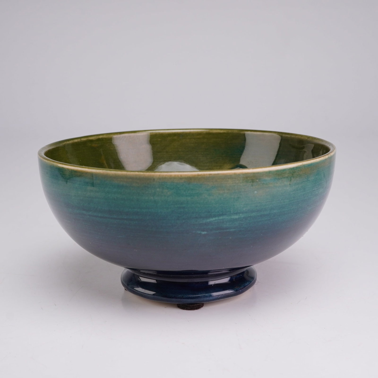 Moorcroft Pottery Footed Bowl, Columbine: This earthenware piece features a rounded body set on a short, flared circular foot. The interior is decorated with a centrally placed, hand-painted floral motif executed with a tubelining technique t