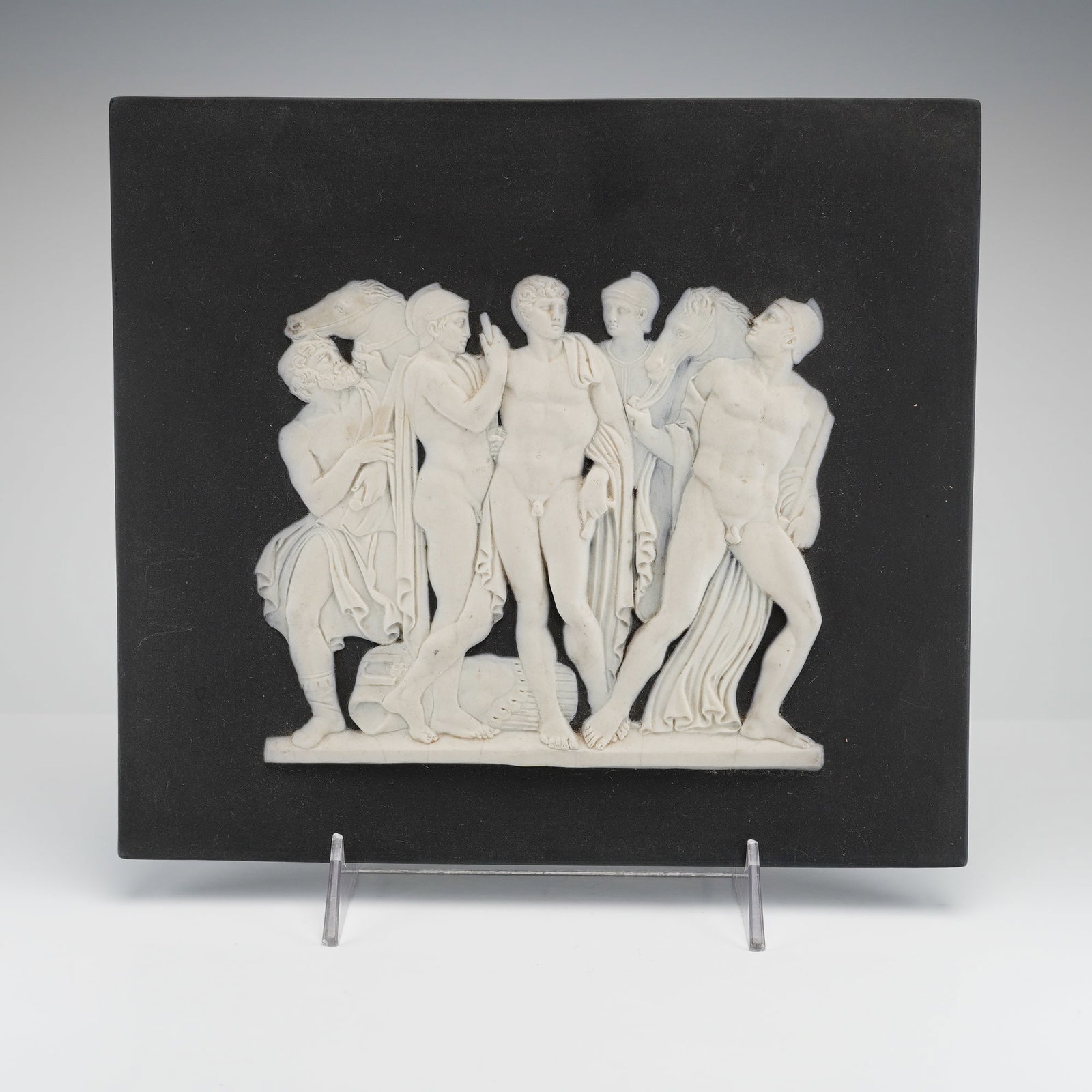 Wedgwood Black Basalt and White Jasperware Plaque: This rectangular Wedgwood plaque is composed of black basalt stoneware featuring a white jasperware relief in the neoclassical style. The composition depicts a group of five male figures, both nude an
