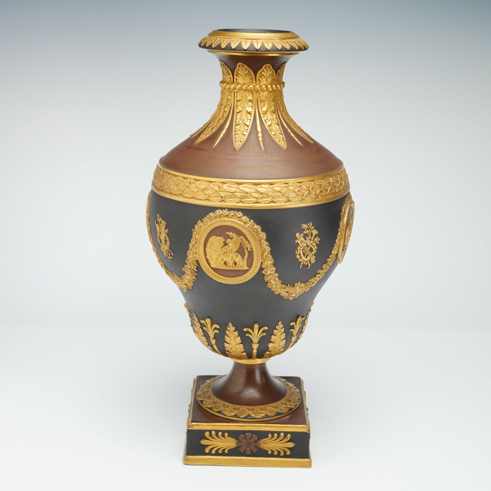 Wedgwood Bronzed and Gilded Black Basalt Vase: This 19th-century Wedgwood neoclassical vase is composed of unglazed stoneware, featuring a combination of black basalt and reddish-brown terracotta-toned bodies. This piece originates from the Dr. El