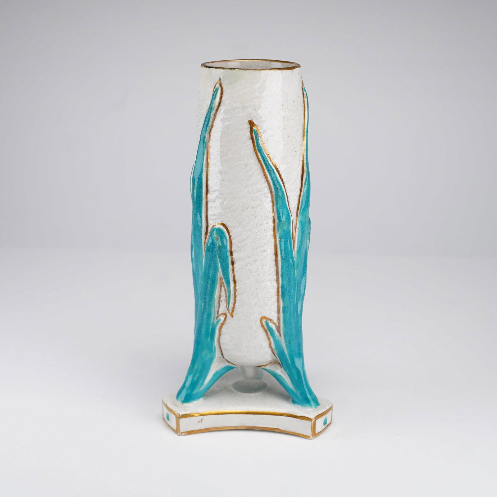 Wedgwood Ceramic Foliate Bud Vase: A ceramic bud vase or taper holder of cylindrical form supported by three molded leaf-form legs on a flared tripartite base. The object features a white glaze with a textured orange peel surface and f
