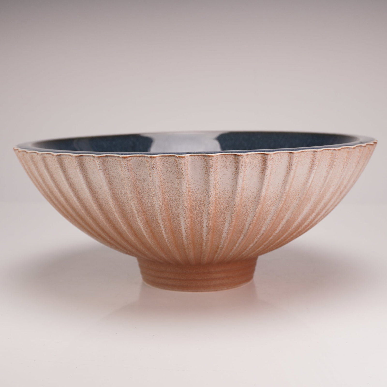Wedgwood Norman Wilson Studio Pottery Fluted Bowl: A high-fired stoneware bowl designed by Norman Wilson for Wedgwood. The vessel features a flared circular form with deep vertical fluting on the exterior, resulting in a scalloped rim. The exterior is