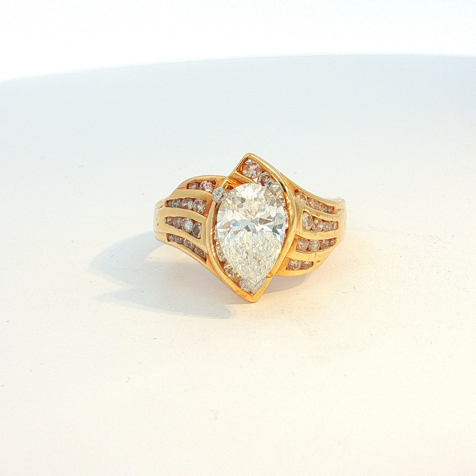 GIA Certified 14K Gold 1.35ct Pear Brilliant Cut Diamond Ring: 14K yellow gold ring featuring a pear brilliant cut diamond (1.35 carats, G color, VS2 clarity) at the center, accompanied by a GIA report. The ring also has round cut diamonds on each shoulder and un