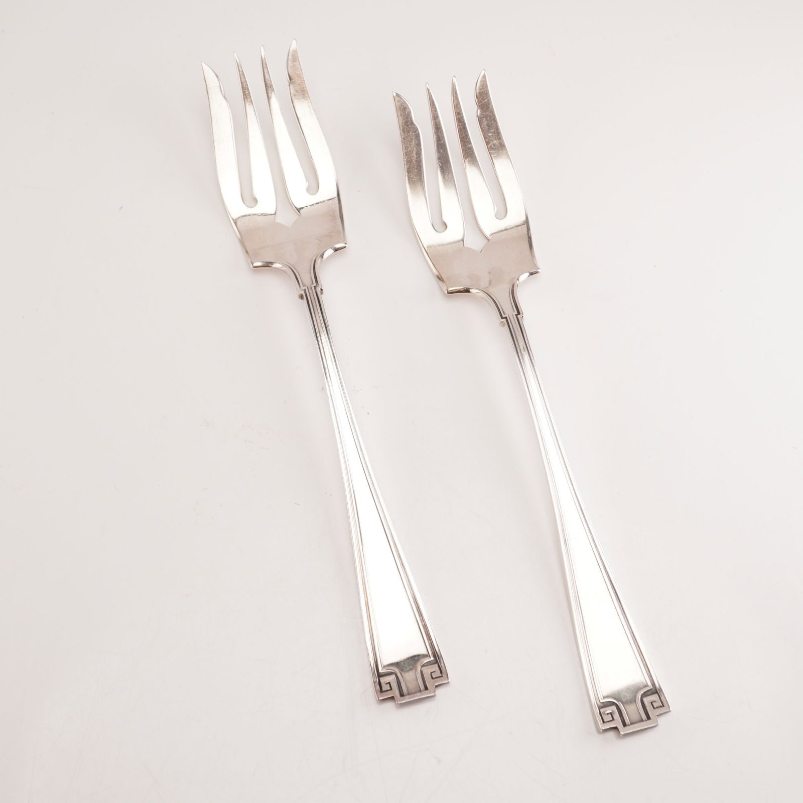 2pc Gorham Sterling Silver Salad Forks, Etruscan: A pair of Gorham sterling silver salad forks in the timeless Etruscan pattern, introduced in 1913 and produced until 1991. The design draws from classical Greco-Roman influences, highlighted by refine