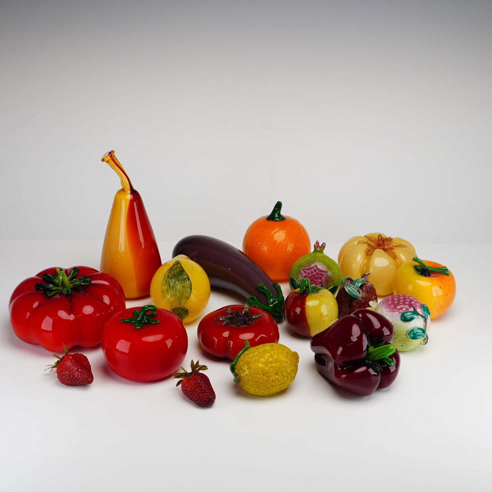 17pc Decorative Murano-Style Glass Fruit and Vegetables: This lot of decorative fruit consists of 17 pieces total, featuring a variety of hand-blown and hand-formed glass items in the Murano style. The collection is characterized by vibrant, saturated color