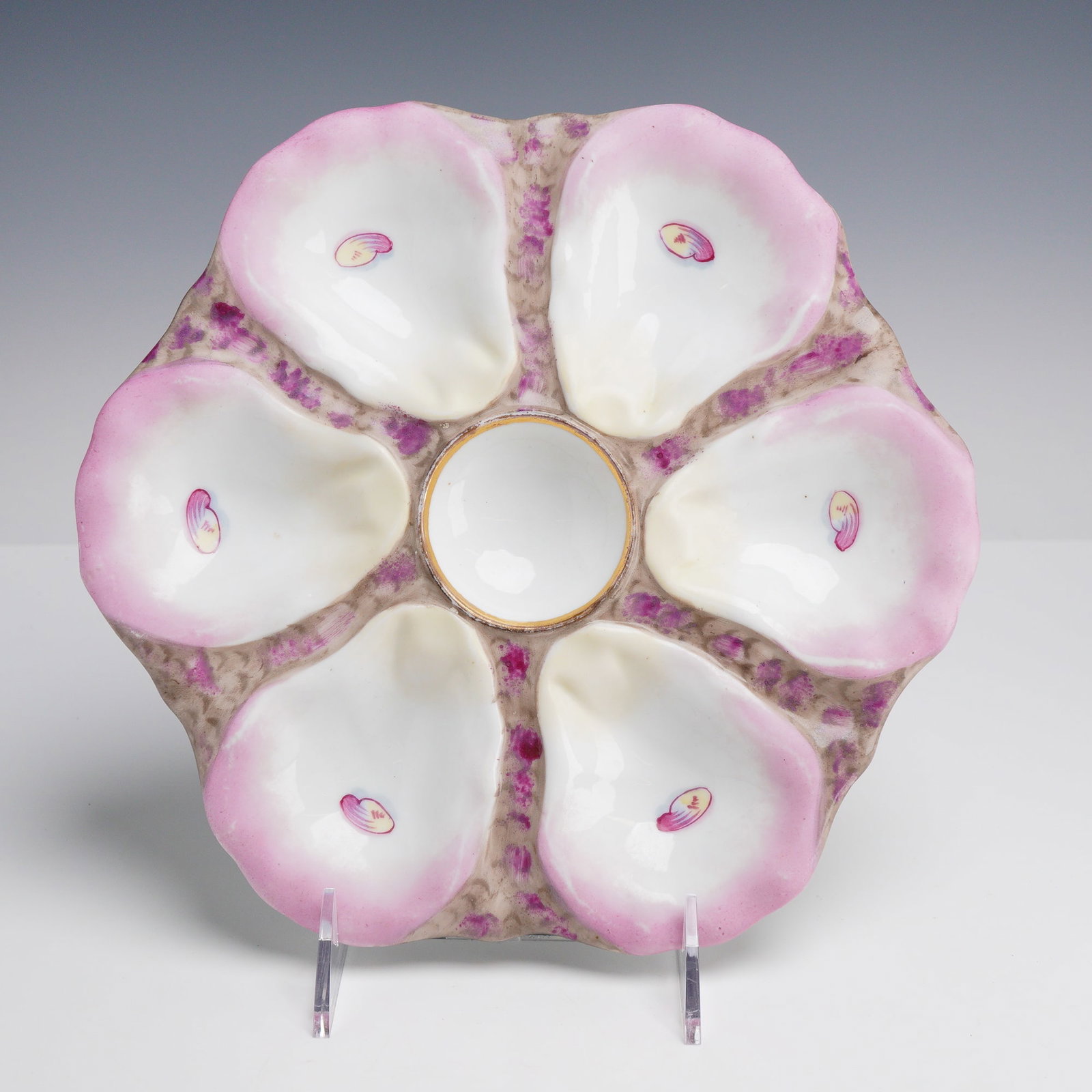 Oyster Plate Shell Pattern Plate OYP43: This Oyster Plate OYP43 features six relief-molded shell wells arranged around a central circular sauce well. The piece displays shell wells finished in a lustrous white glaze with hand-painted pale p