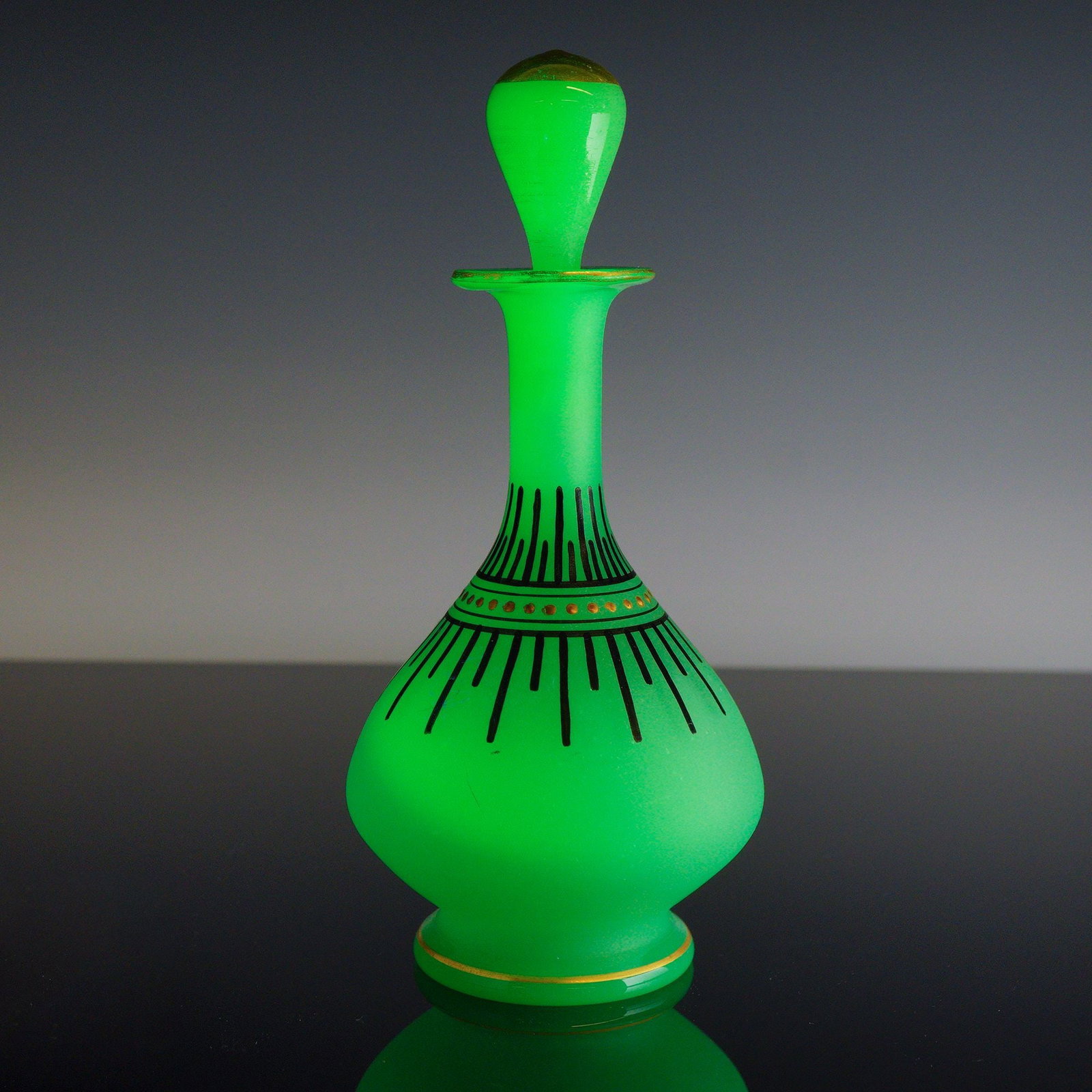 Art Deco Style Uranium Glass Decanter with Stopper: An Art Deco style decanter with a matching stopper, crafted from uranium green glass with a frosted satin finish. The piece features a bulbous body tapering to a tall neck with a flared rim. The exter