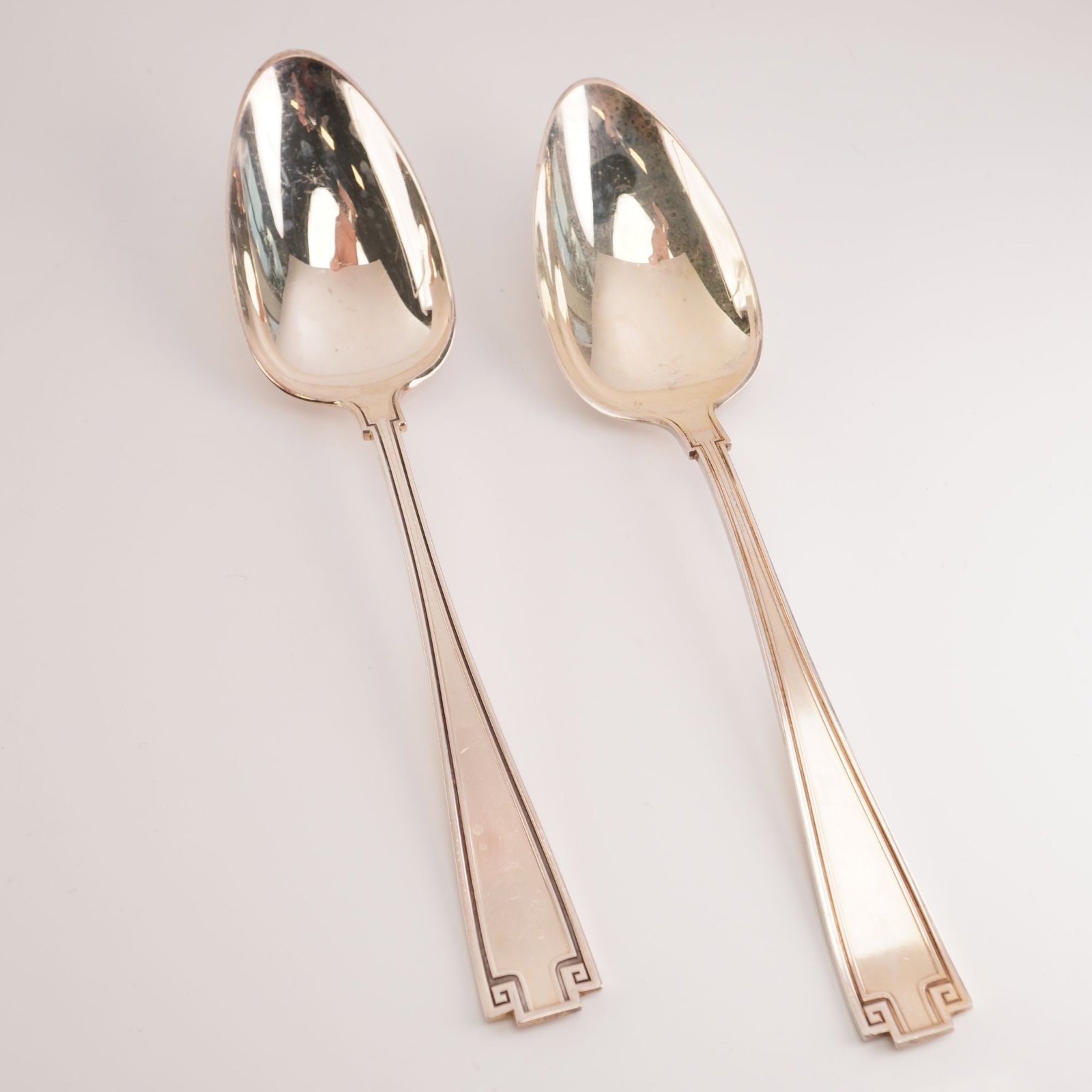 2pc Gorham Sterling Silver Oval Dessert Spoons, Etruscan: Manufactured between 1913 and 1991, this Gorham design embodies a Greco-Roman revival aesthetic, featuring balanced symmetry and a classic Greek key border detail. Introduced in the early 20th