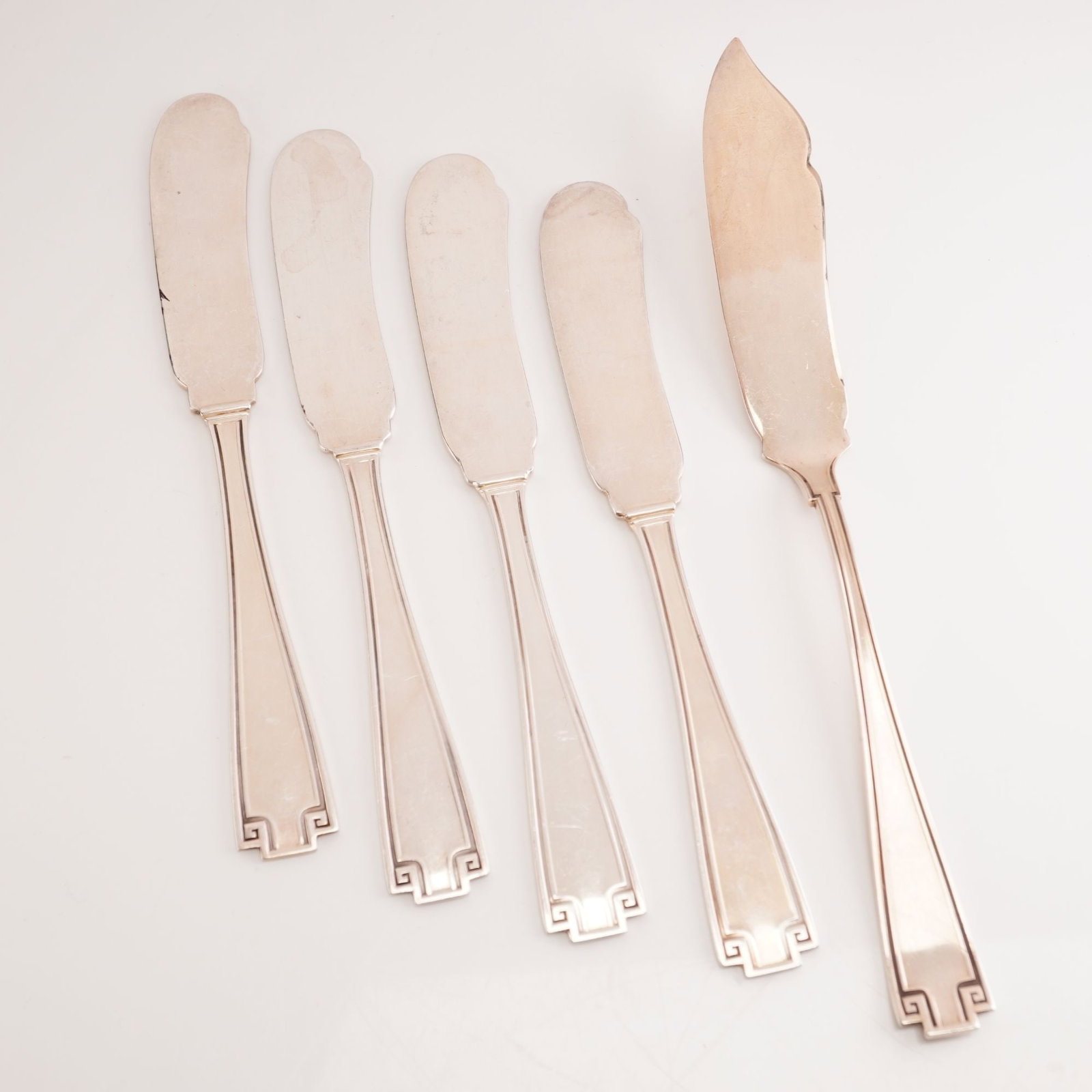 5pc Gorham Sterling Silver Flat Handle Butter Spreaders and Master Butter Knife, Etruscan: Featuring four flat-handle butter spreaders and one master butter knife. The Etruscan pattern, produced between 1913 and 1991, is a Greco-Roman revival design distinguished by its balanced symmetry