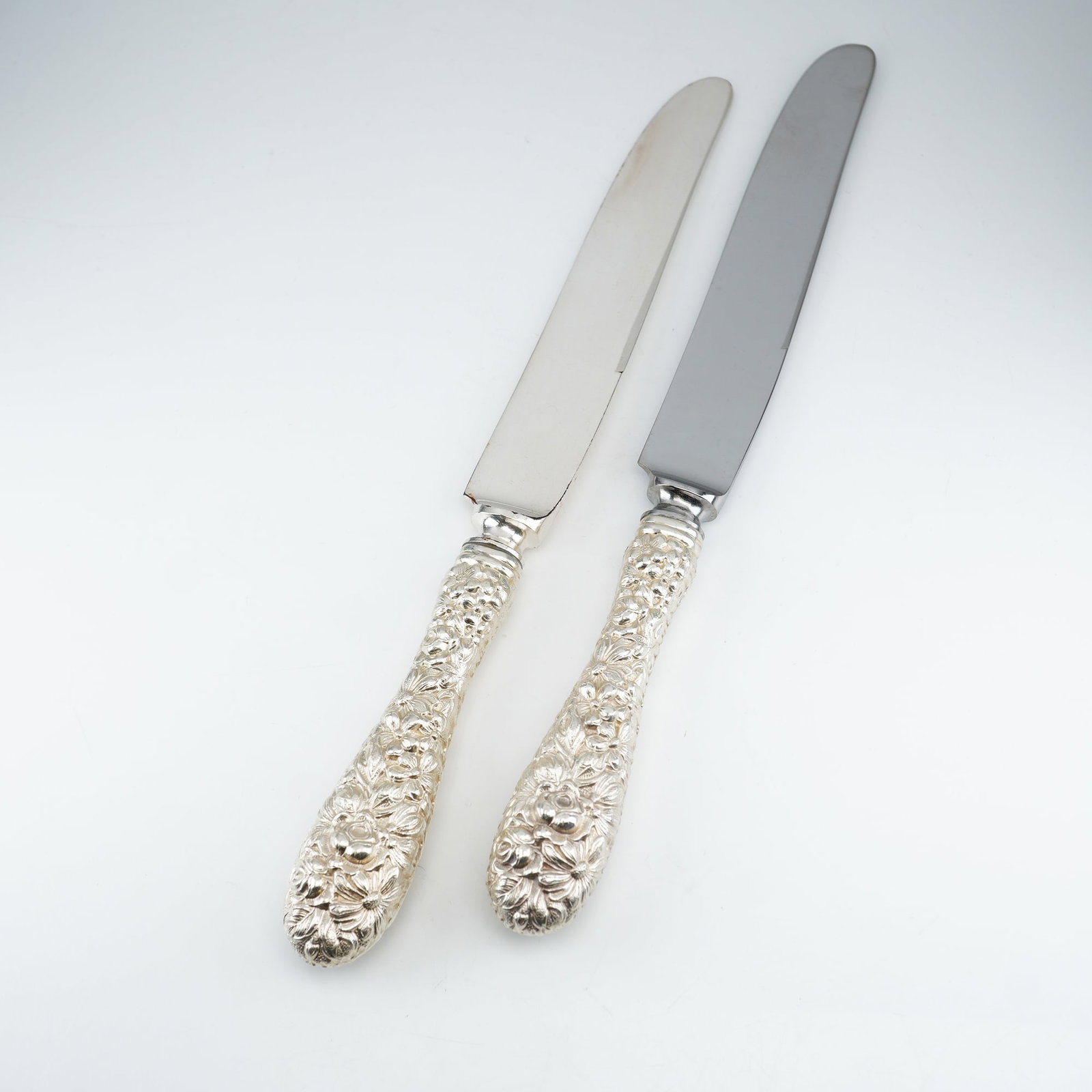 2pc Kirk Stieff Sterling Silver and Stainless-Steel Dinner Knives, Stieff Rose: Set of two dinner knives in the classic Stieff Rose pattern by Kirk Stieff, a design first introduced in 1892. Each knife features an ornate sterling silver handle with floral repousse detailing in