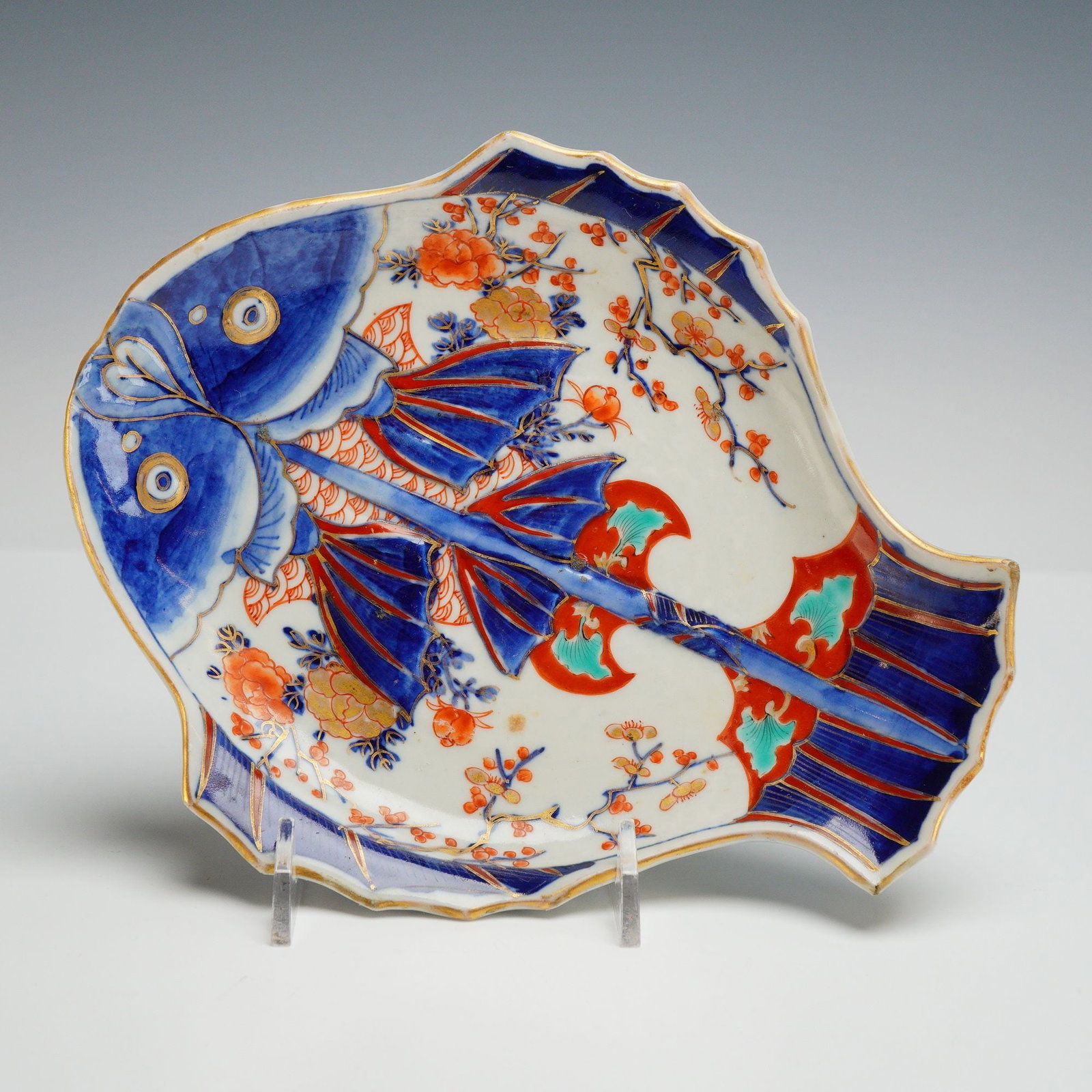 Japanese Imari Porcelain Fish Dish: A Japanese Imari porcelain dish molded in the form of a flatfish, likely a hirame or flounder, dating to the Meiji period (1868-1912). The piece is decorated in a traditional palette featuring undergl