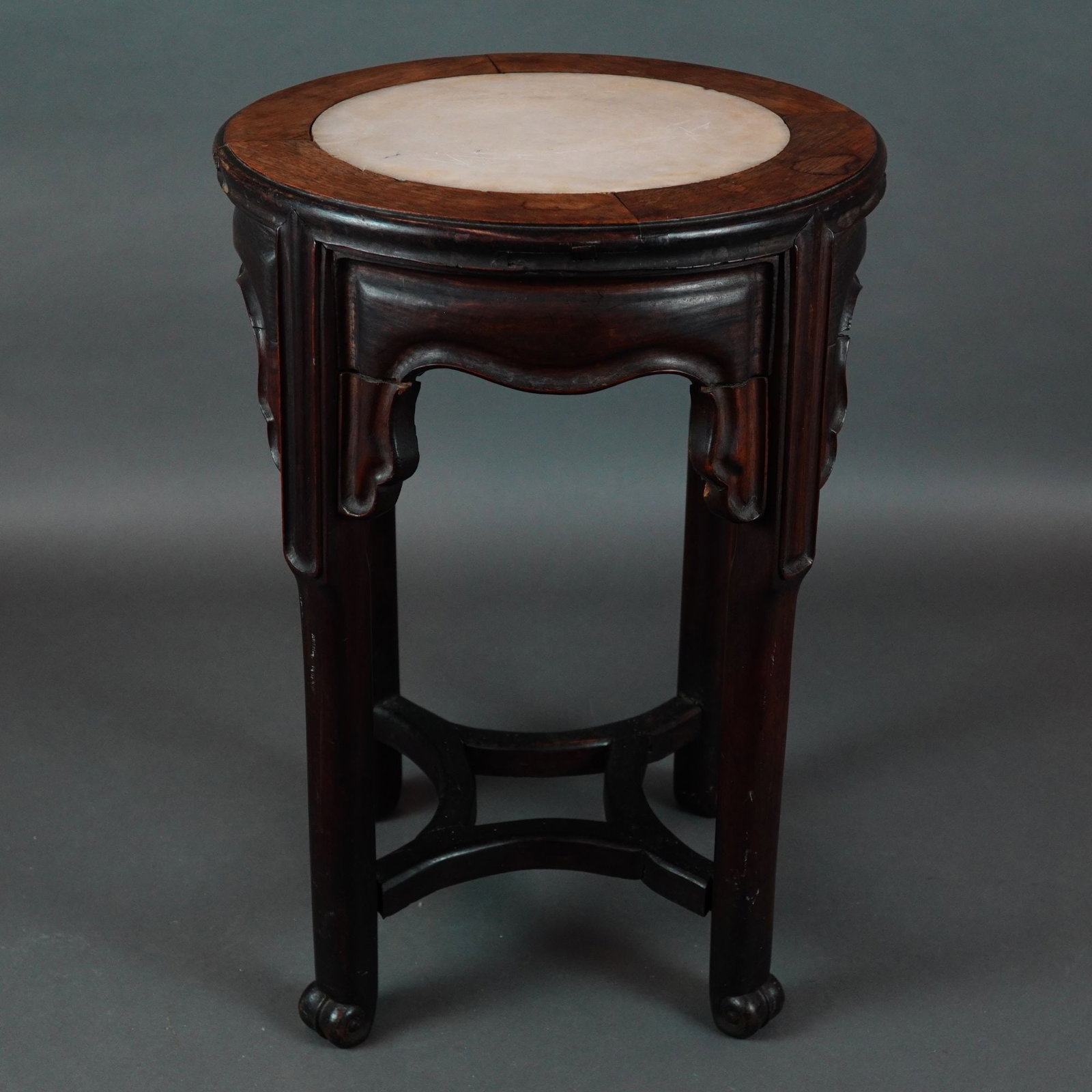 Chinese Hardwood and Marble-Inset Circular Garden Seat Plant Stand, Late 19th to Early 20th Century: This Chinese hardwood and marble-inset garden seat features a circular top with a segmented dark hardwood frame. The frame is inset with a white and gray veined marble panel and has a molded outer edg