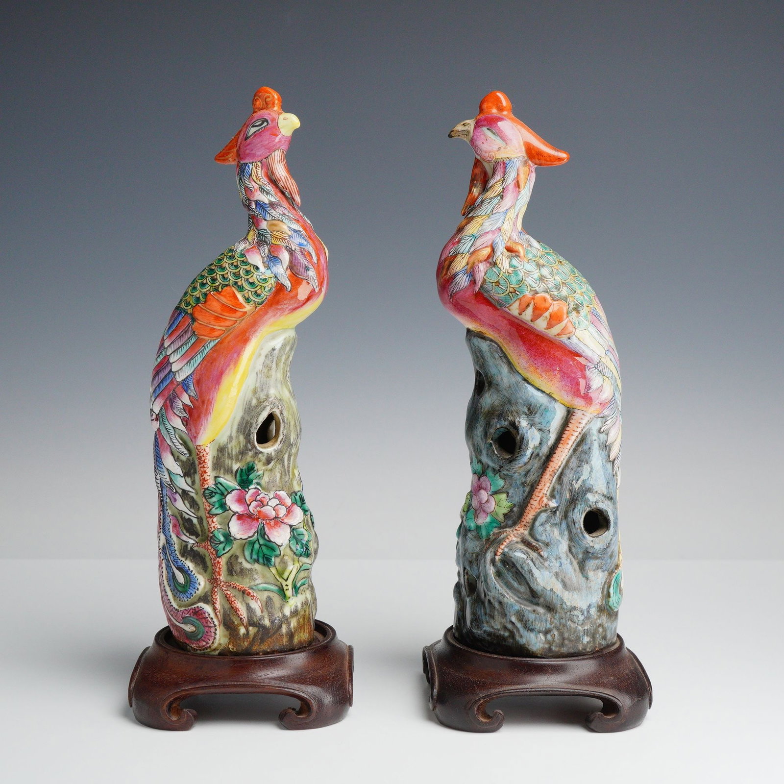 2pc Chinese Export Famille Rose Porcelain Phoenix Figurines: A pair of small size Chinese export porcelain figurines, each depicting a stylized phoenix perched on a gnarled rockery base. The figurines are decorated with a traditional famille rose polychrome ena