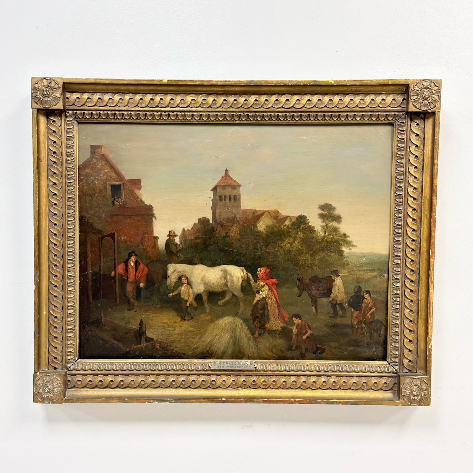 Attributed to Sir David Wilkie (Scottish, 1785-1841), Oil on Board, Der Pferdekauf: This oil on wooden board depicts a bustling rural genre scene, identified by an affixed metal frame plate as 'Der Pferdekauf' (The Horse Purchase). The composition is centered on a white horse being l