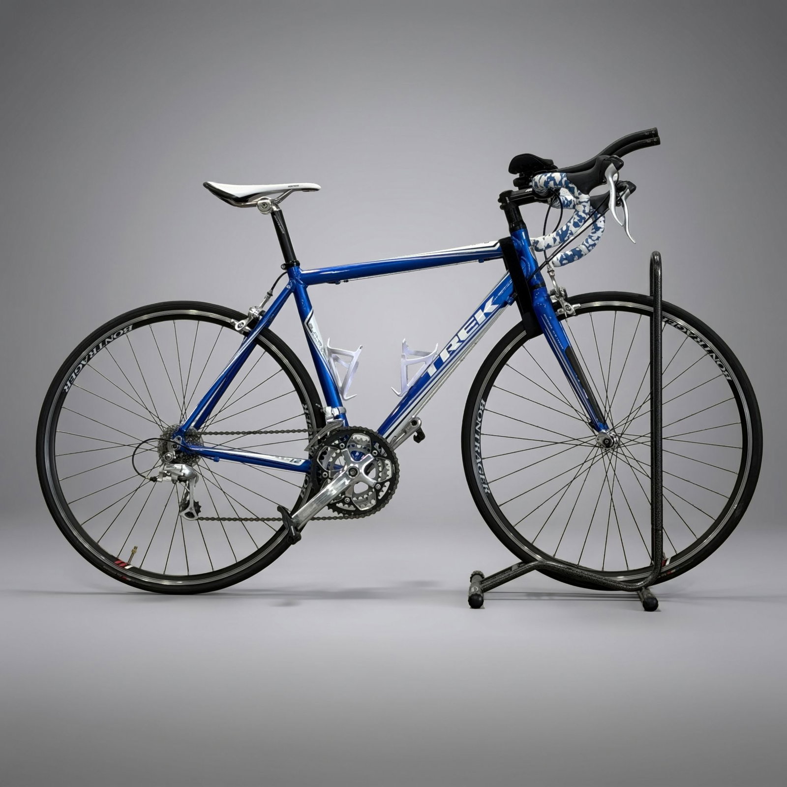 Trek 1.2 Alpha Aluminum Road Bicycle: This Trek 1.2 road racing bicycle is constructed with an Alpha Aluminum frame and a Bontrager HCM Carbon fiber fork. The frame features a blue finish with white and silver graphic accents, including