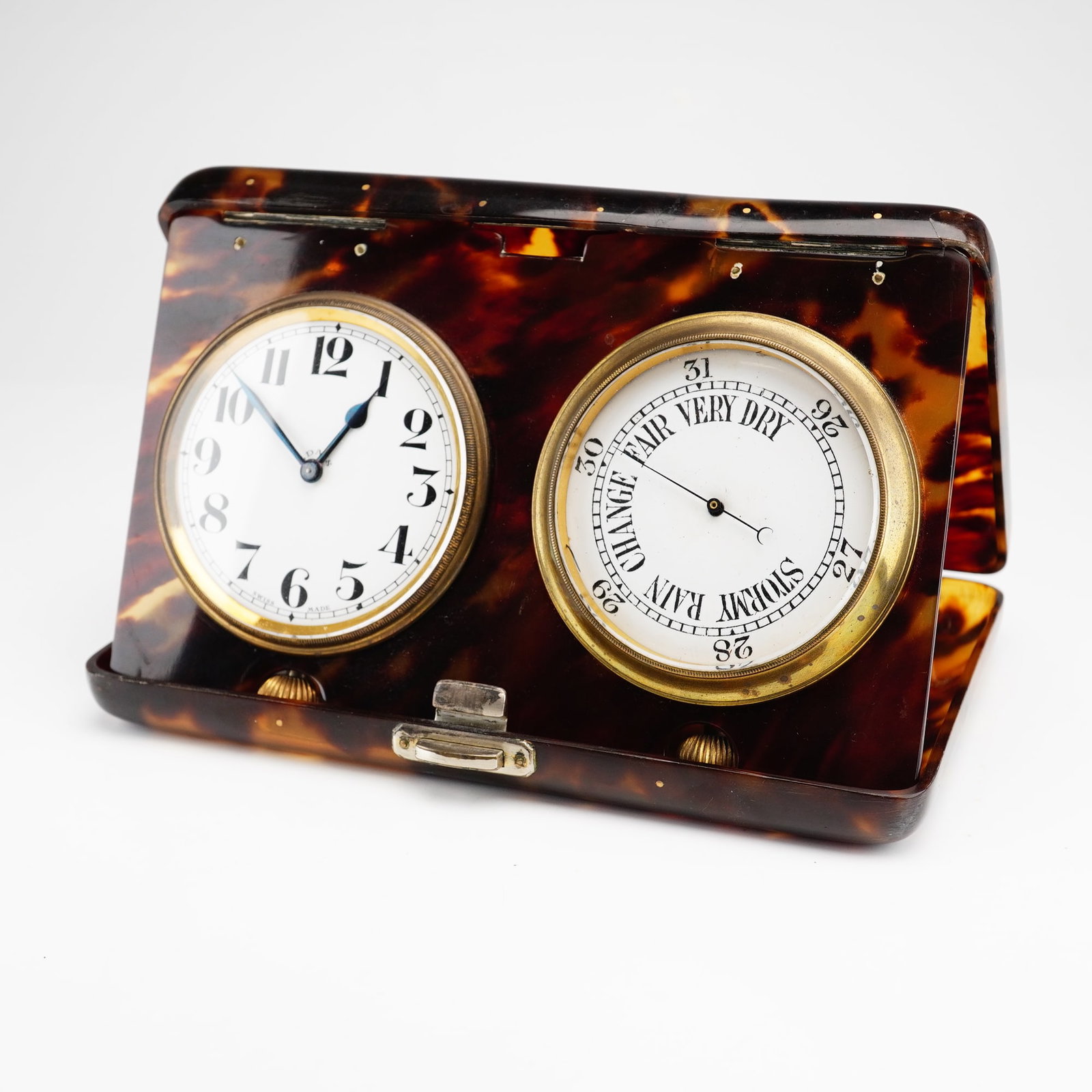 Swiss Made Folding Travel Desk Set with Clock and Barometer: A Swiss made folding travel desk set featuring an 8-day clock and an aneroid barometer. The set is housed in a rectangular easel-back case with a mottled brown faux-shell finish. The case is