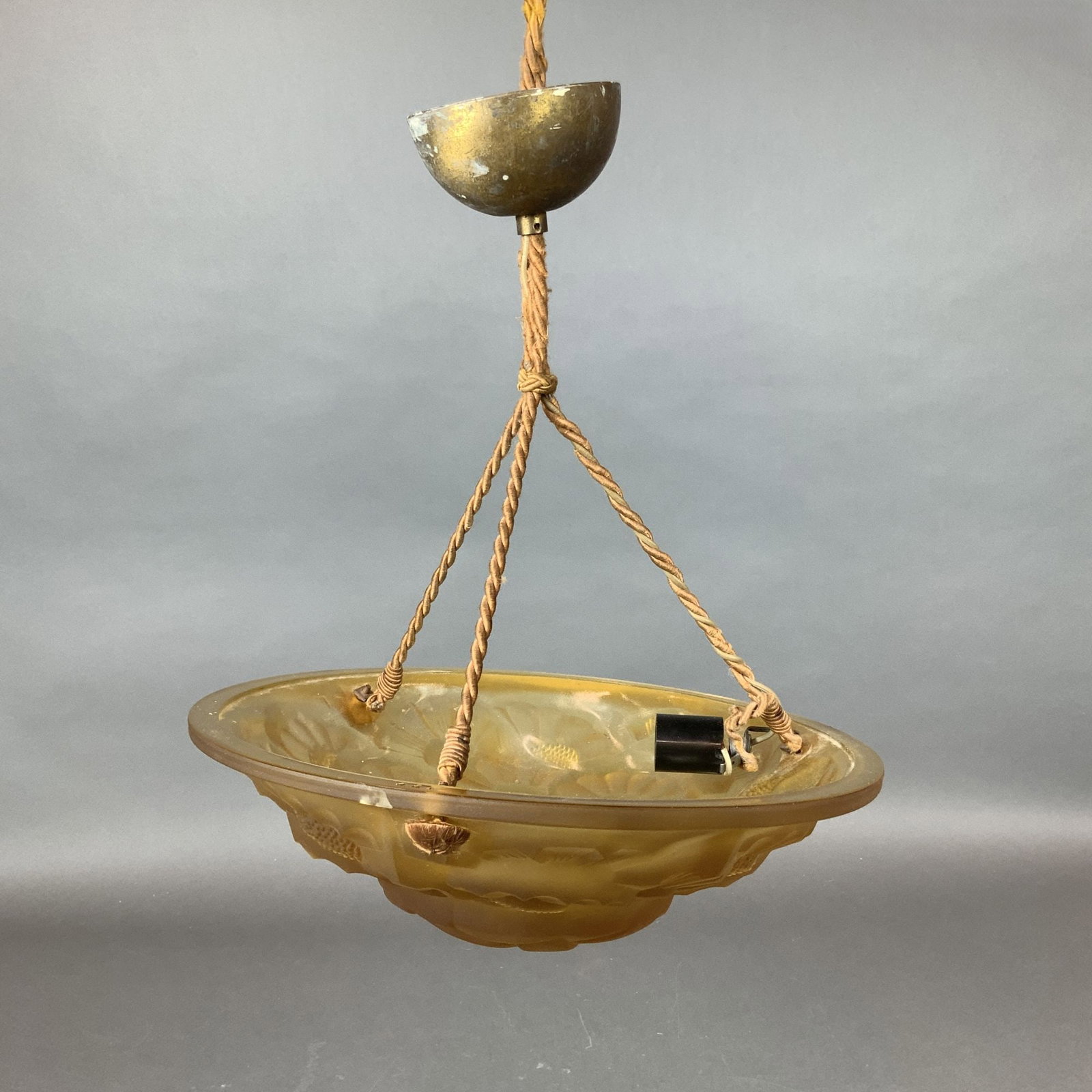 Degue French Art Deco Amber-Colored Glass Ceiling Lamp: French Art Deco ceiling lamp dating to circa 1930. The fixture features a crafted solid glass shade in a soft amber tone, decorated with refined floral motifs characteristic of the period. Retains