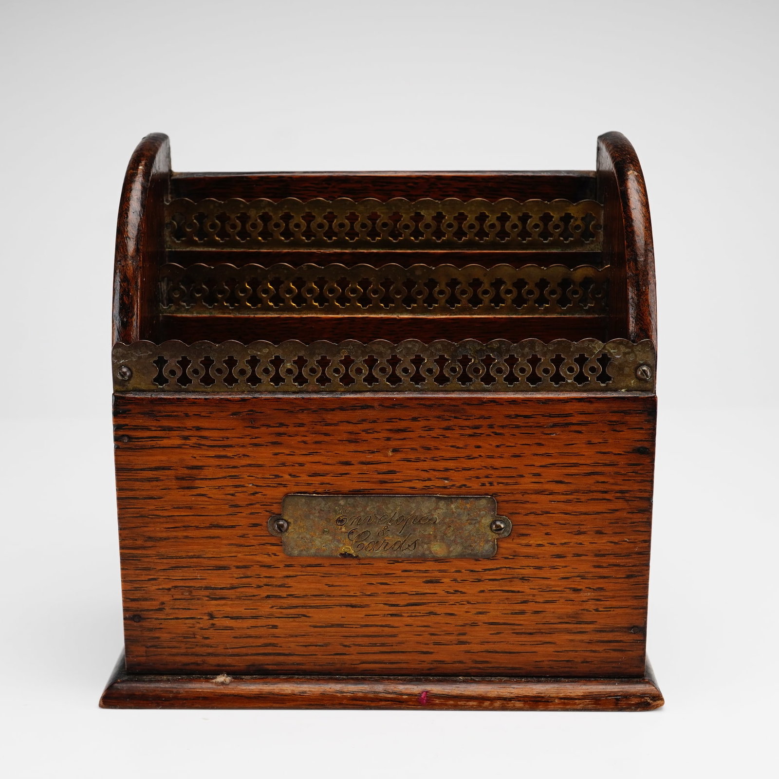 English Oak and Brass Letter Holder: An English desk stationery rack and letter holder/organizer in the Victorian style, constructed of dark-stained oak and brass. The item features a tiered, three-compartment design for the storage of